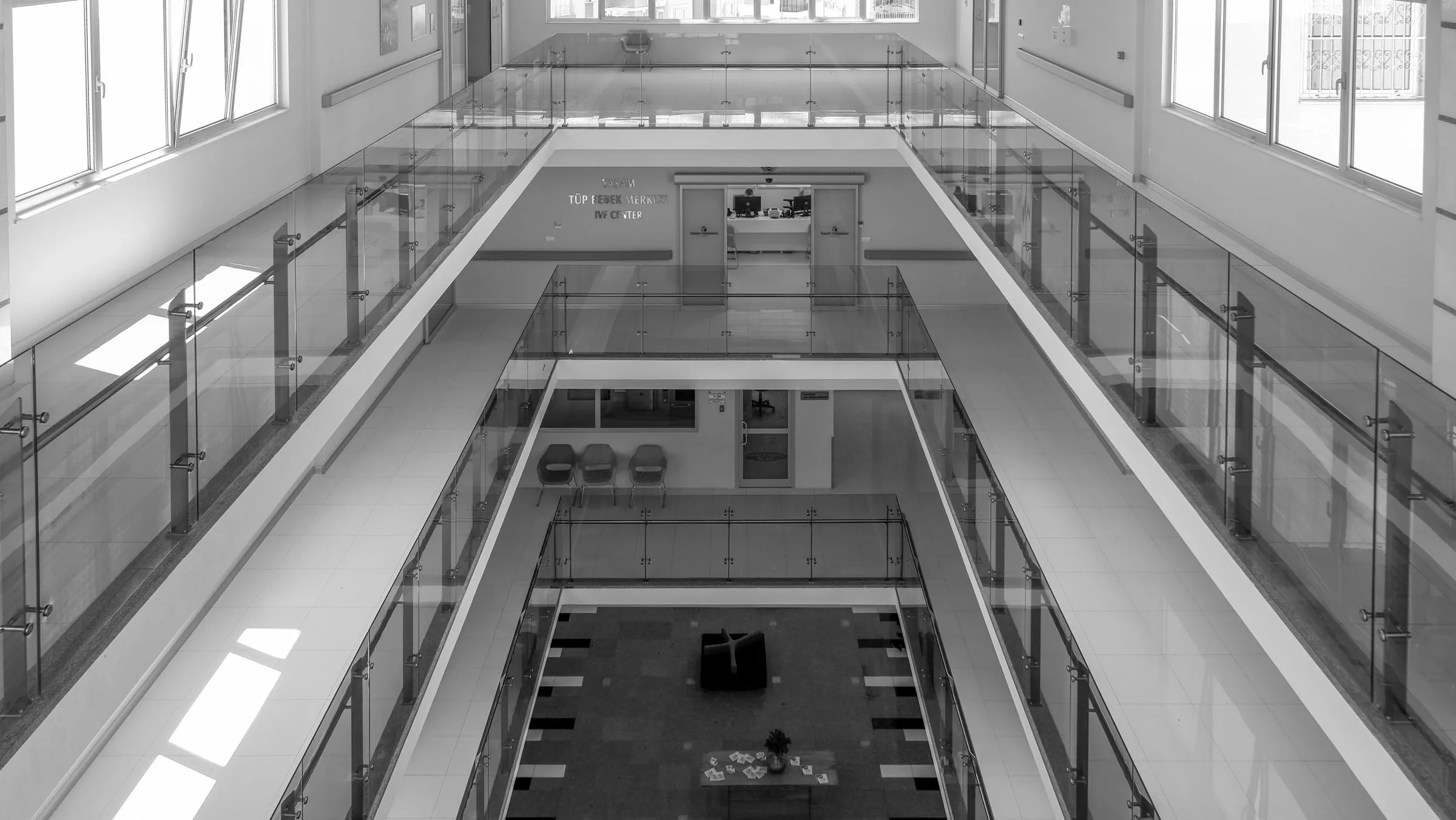Atelier 27 arrival level, looking across glass balustrades to the studio floor below.