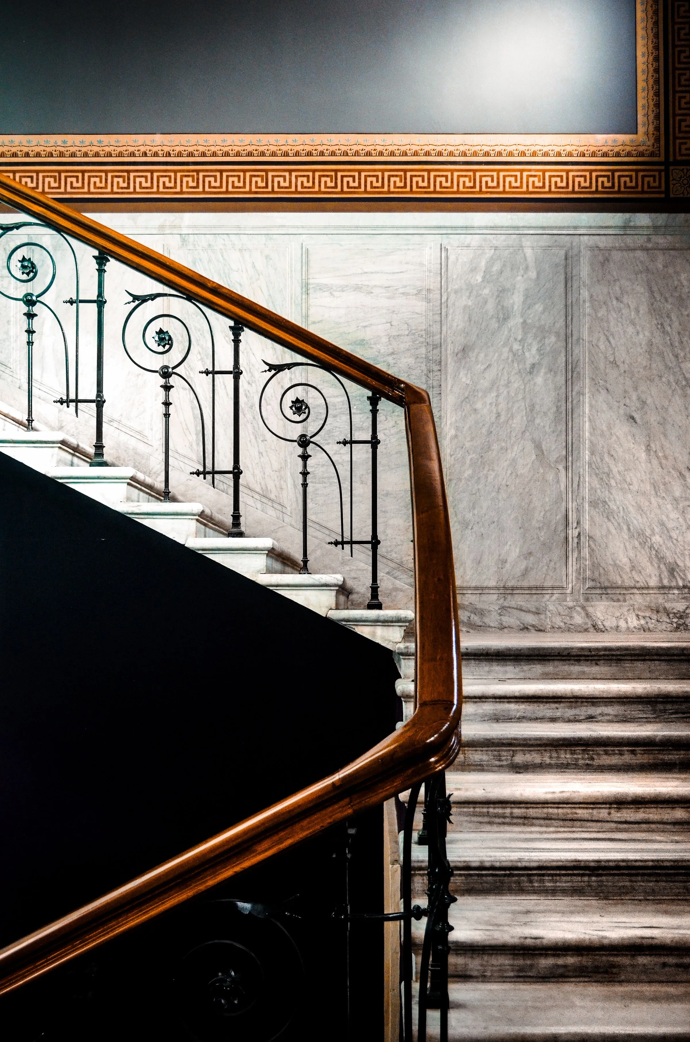 Marble staircase at Maison No. 8 with an ironwork balustrade.