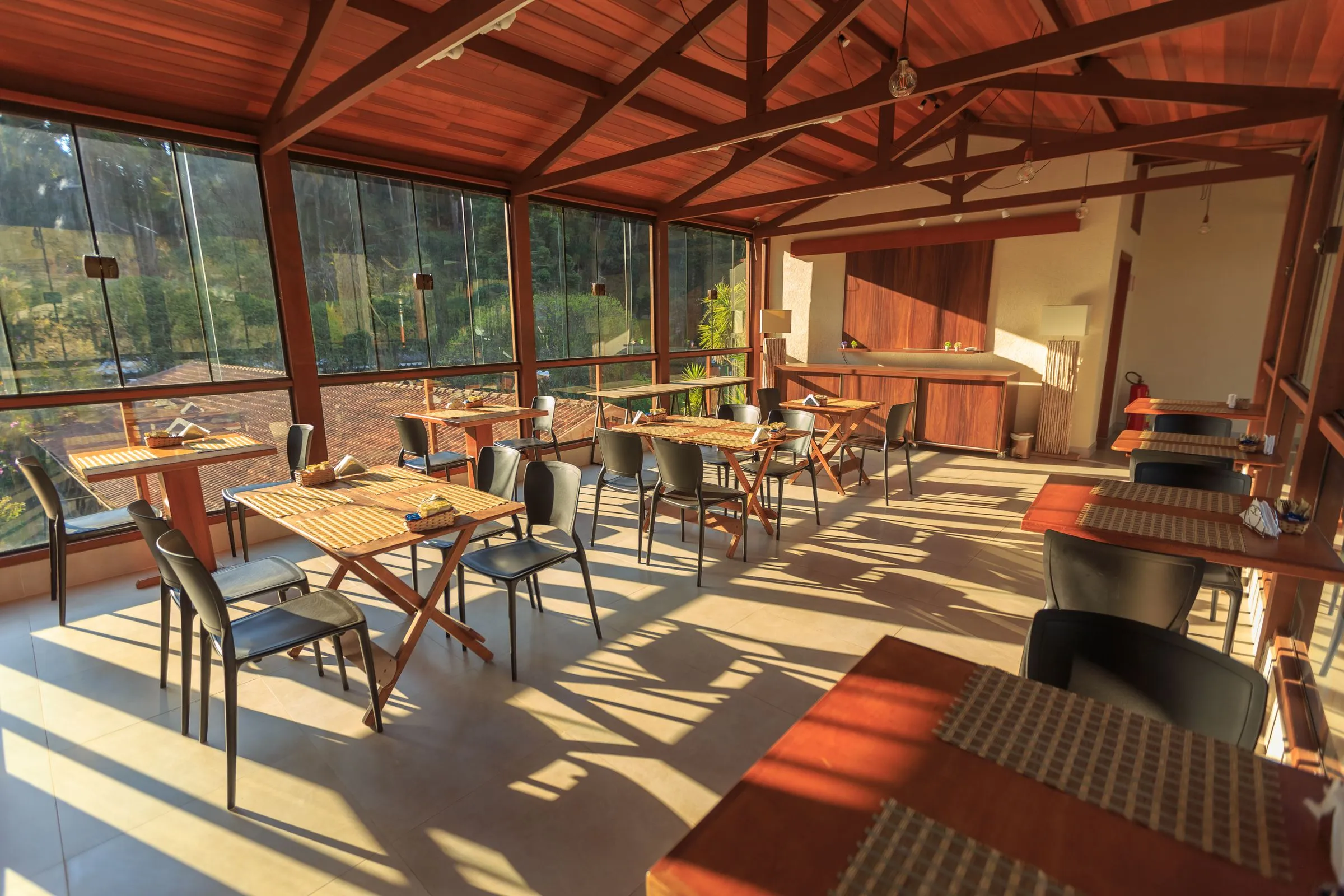 Forma Café in the morning, with timber tables under a pitched roof and long shadows across the floor.