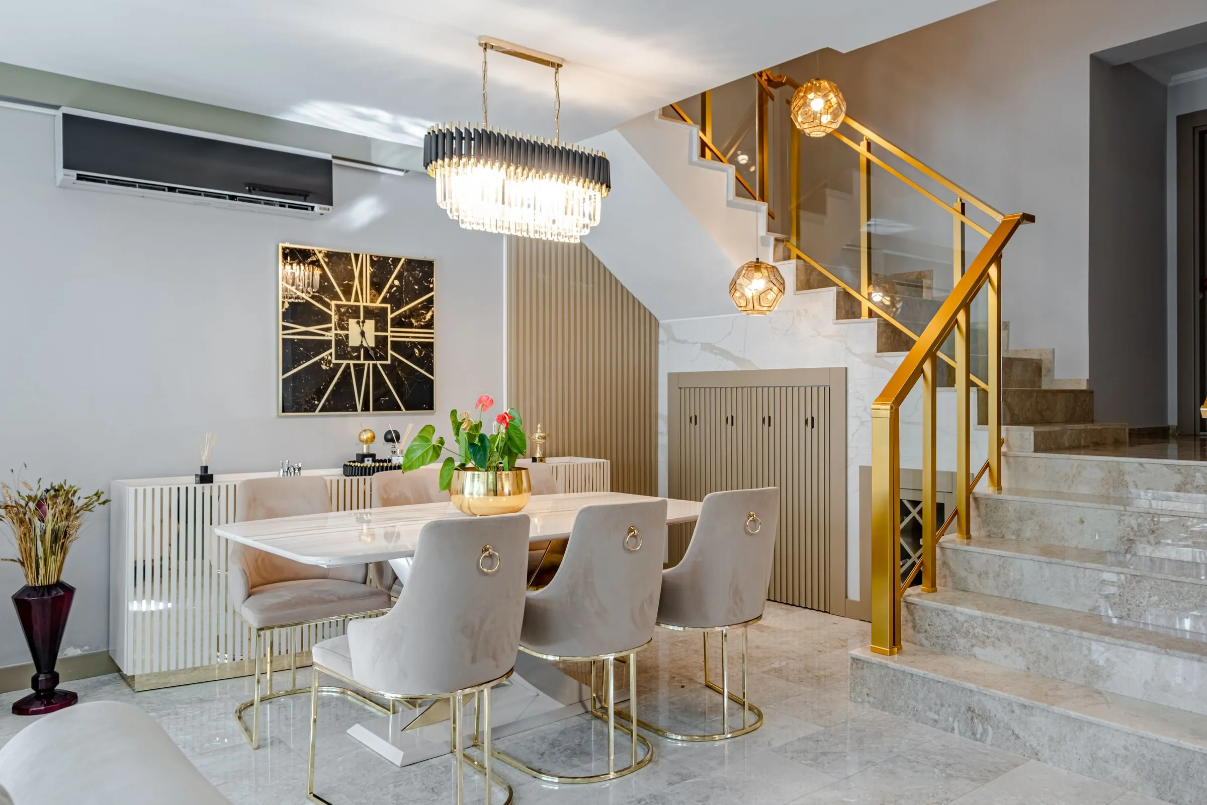 Serein dining area with a marble table, sculptural pendant light and upholstered chairs.