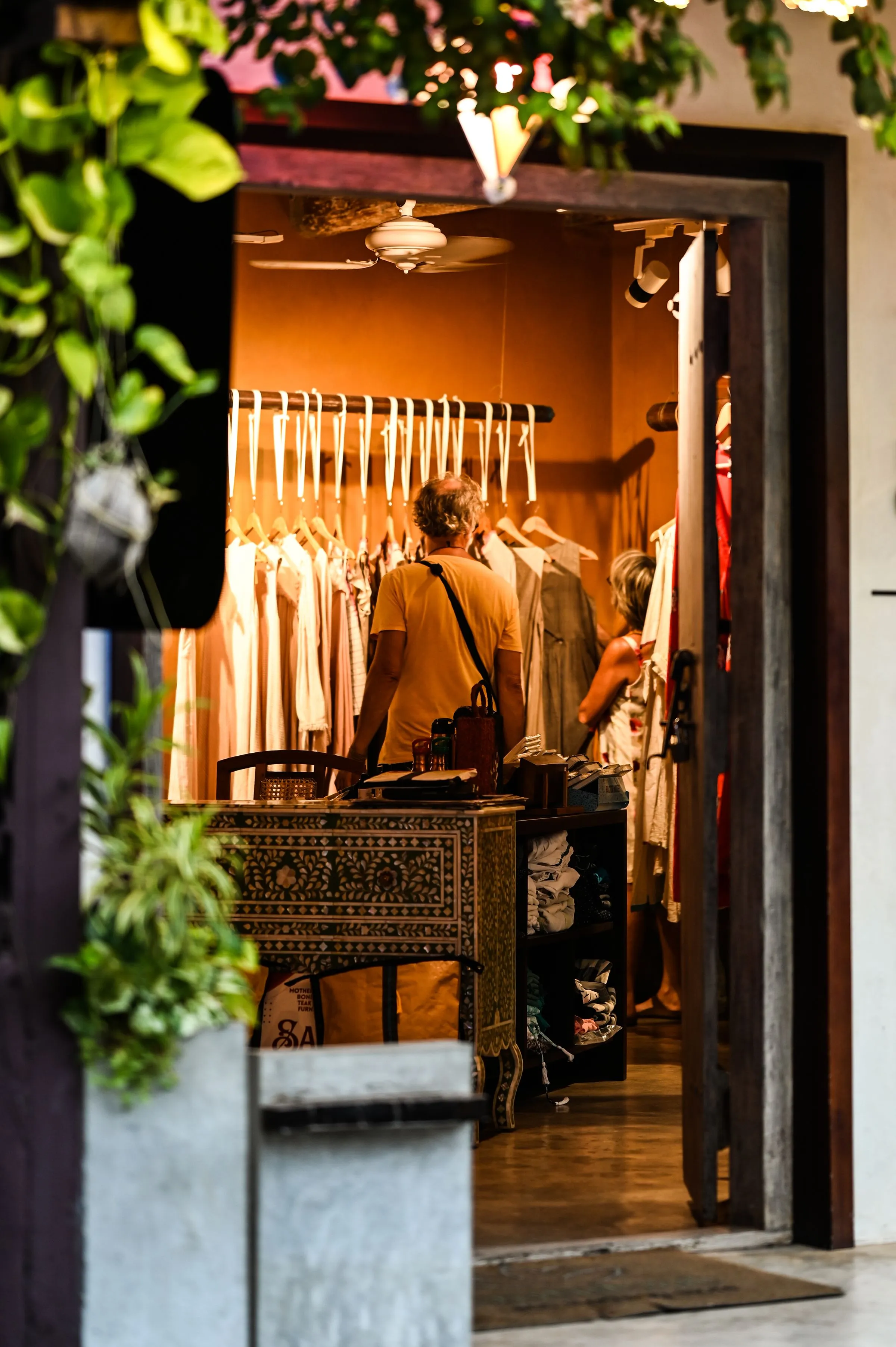 Clothing rails and browsing space at Vault & Vine with customers looking through garments.
