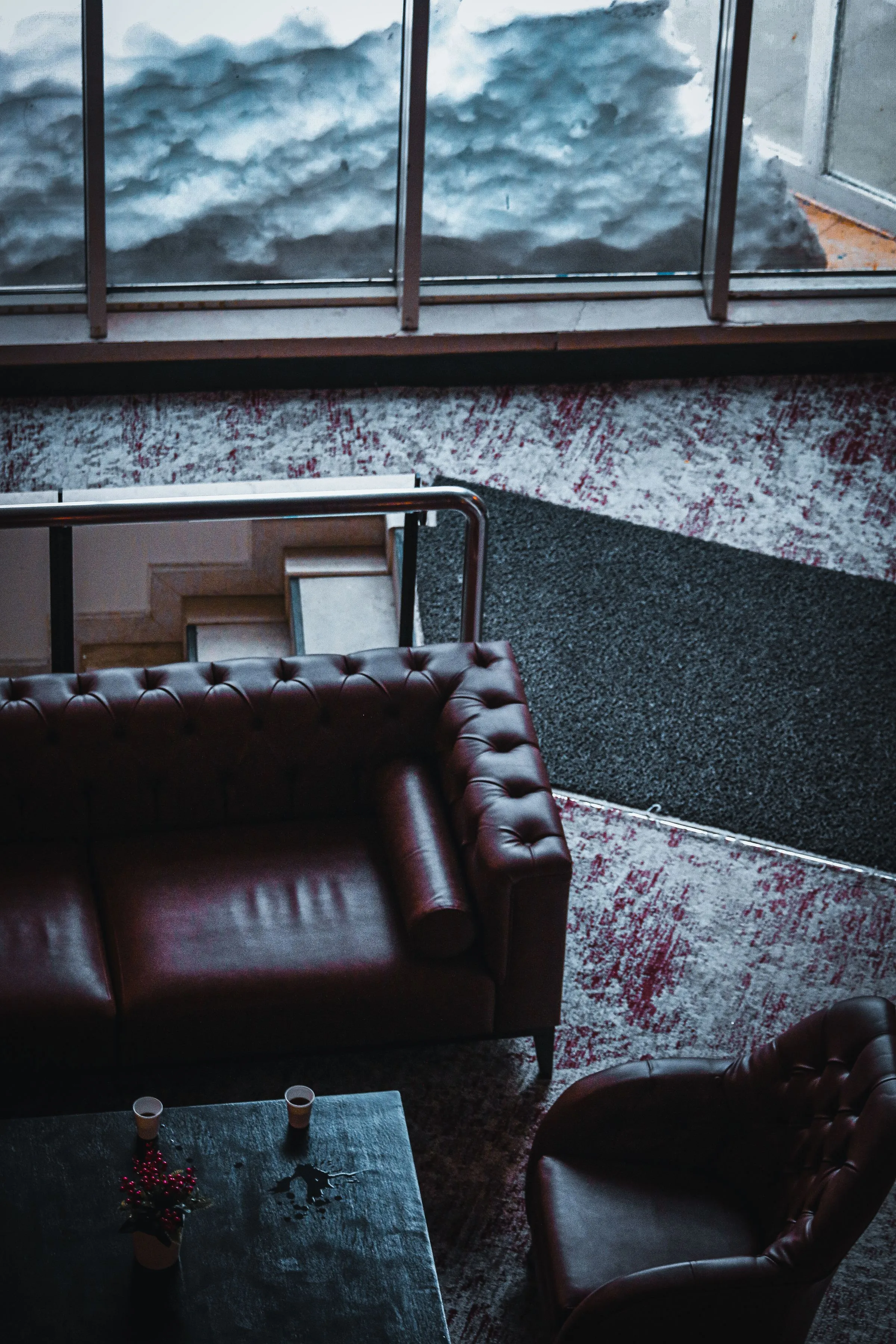 Lounge at Maison No. 8 with leather seating and tall windows onto the garden.