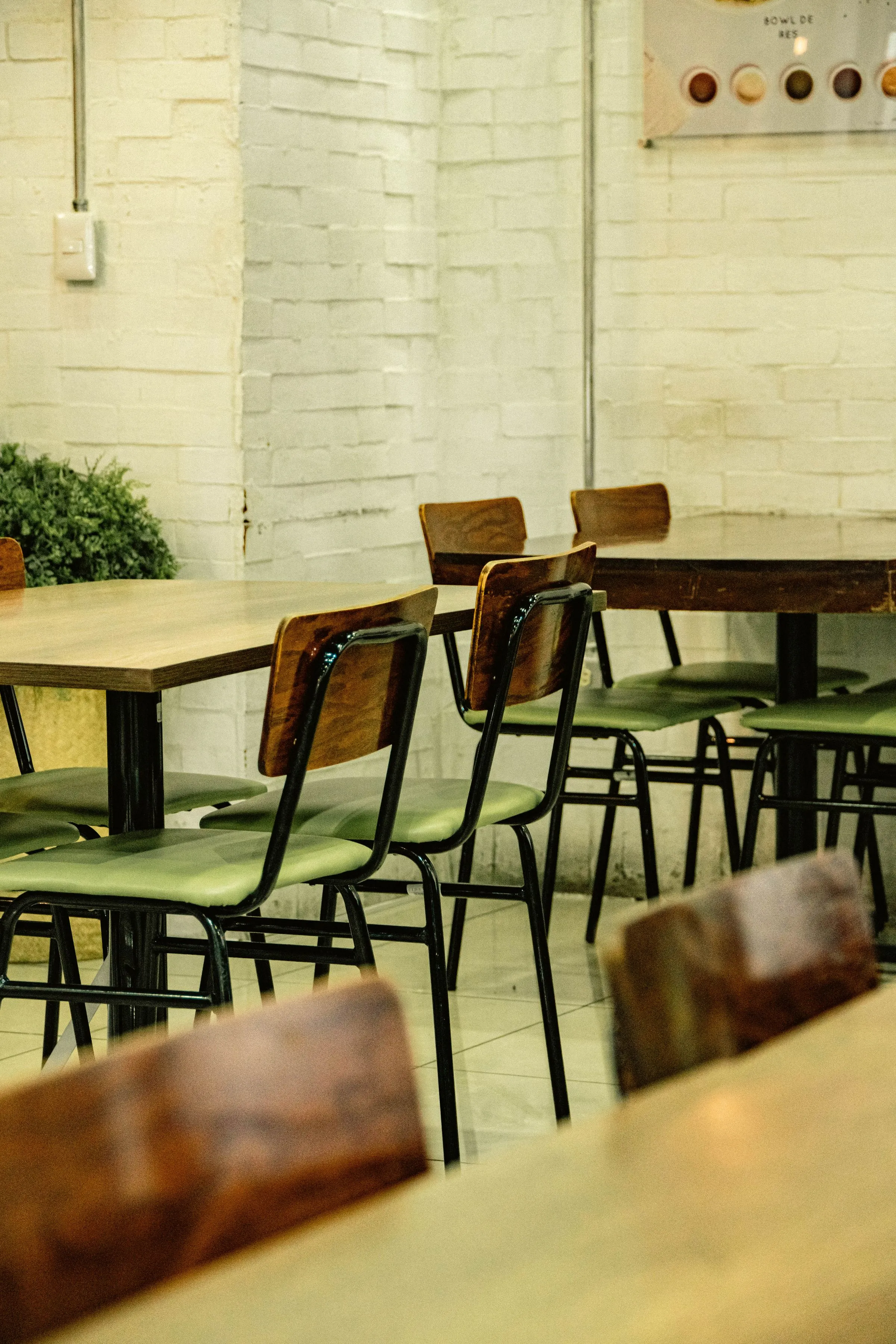 A dining room with timber chairs and tables set for casual service.