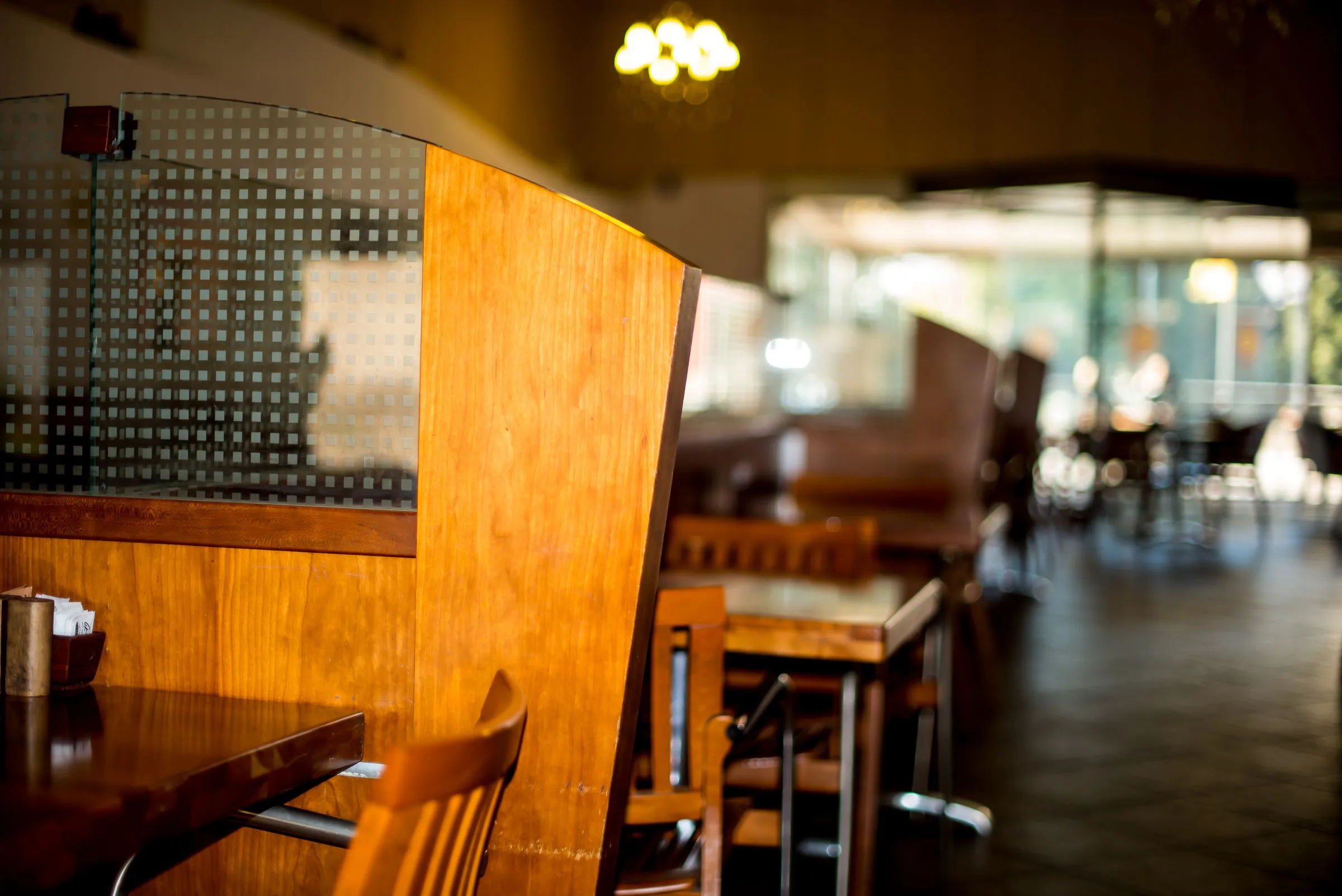 Forma Café at service, with timber tables and chairs under warm ambient light.