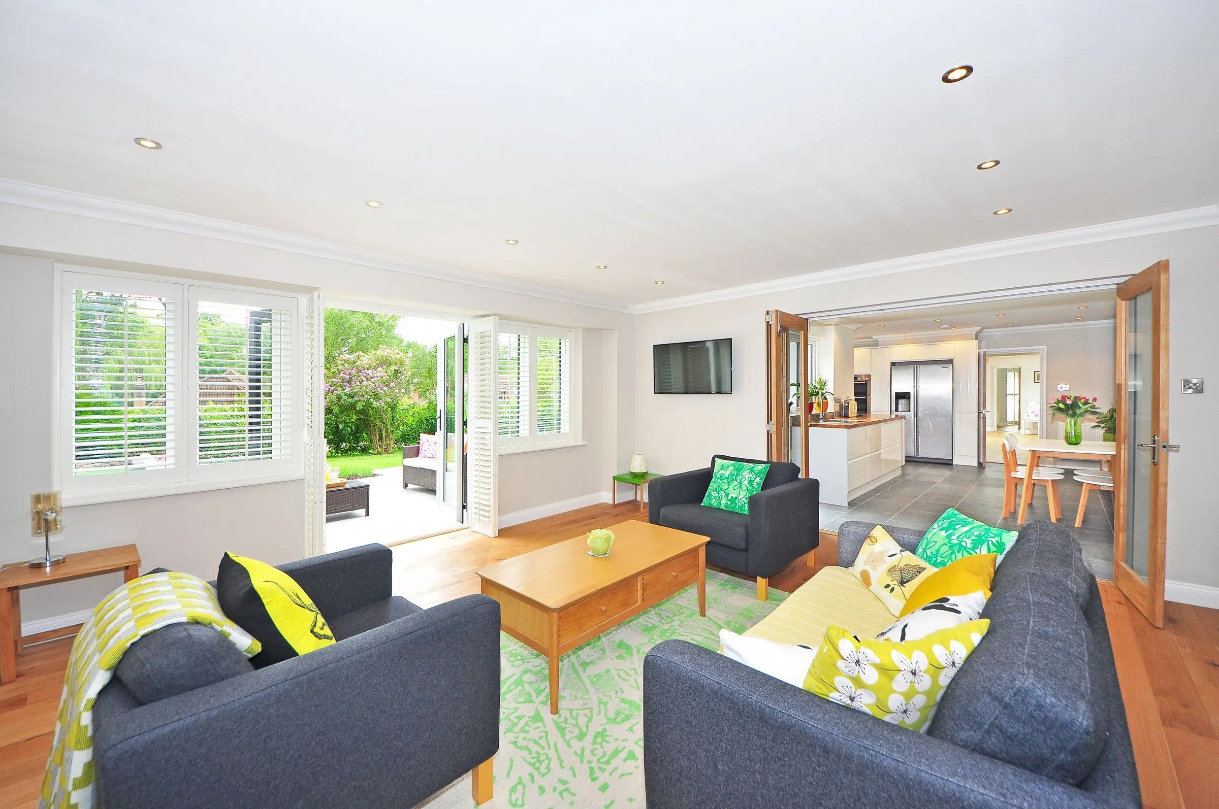 Living room at The Oak House opening onto a garden through full-height glazing.