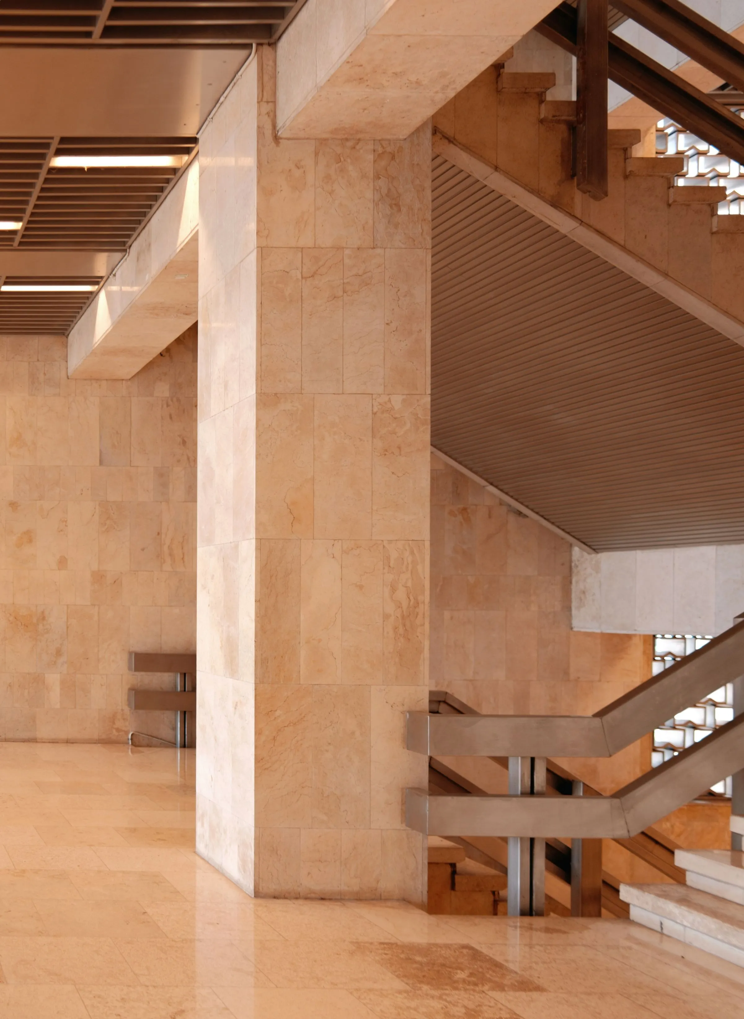 A geometric staircase and balustrade seen from an upper floor.