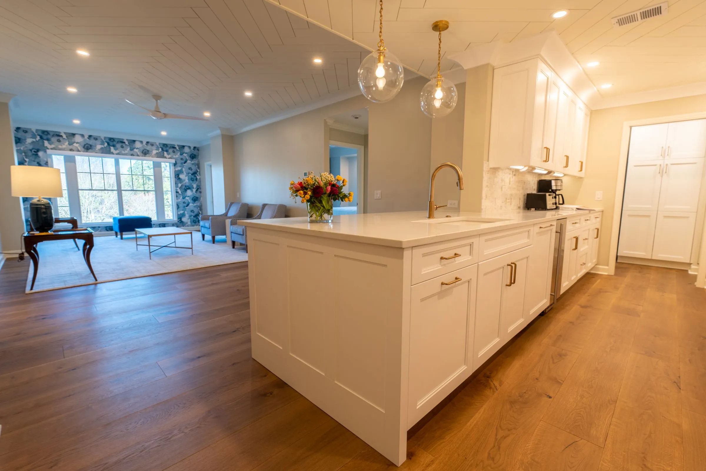 A bright kitchen wrapping three walls, with hardwood flooring throughout.
