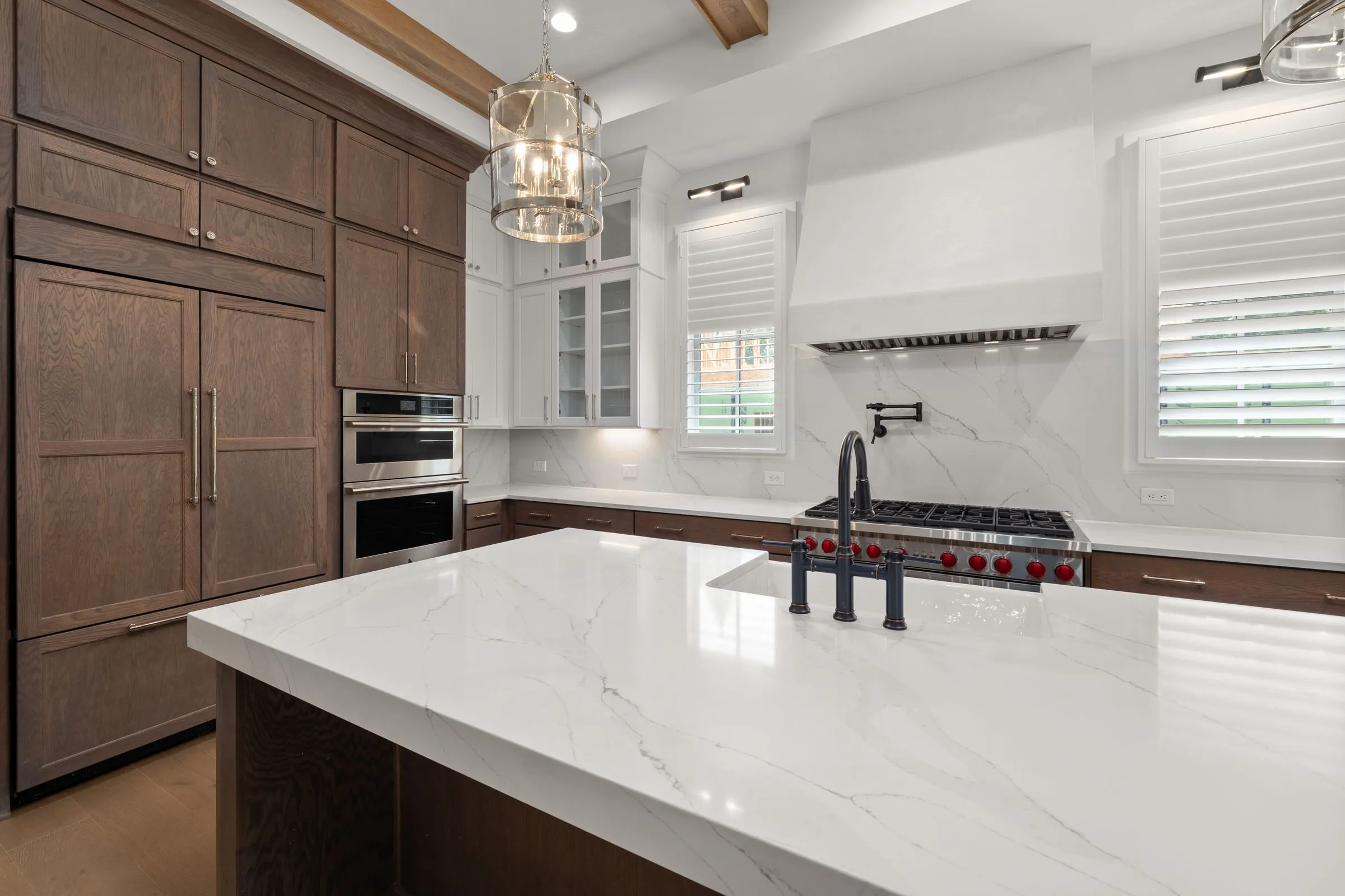 Kitchen at Maison No. 8 with a marble island, timber cabinetry and integrated appliances.