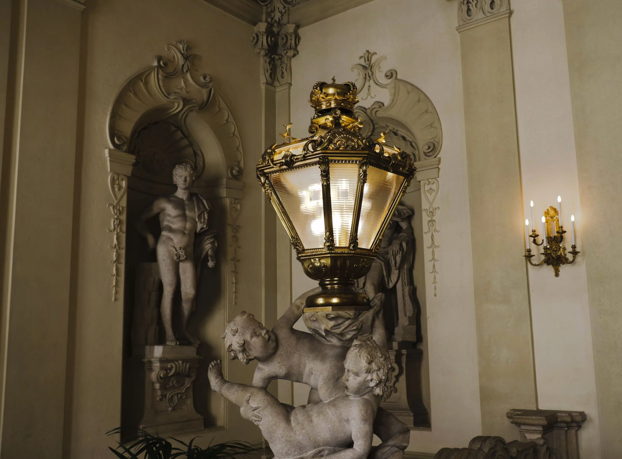 A classic interior with ornate plasterwork and a tall standing lamp.