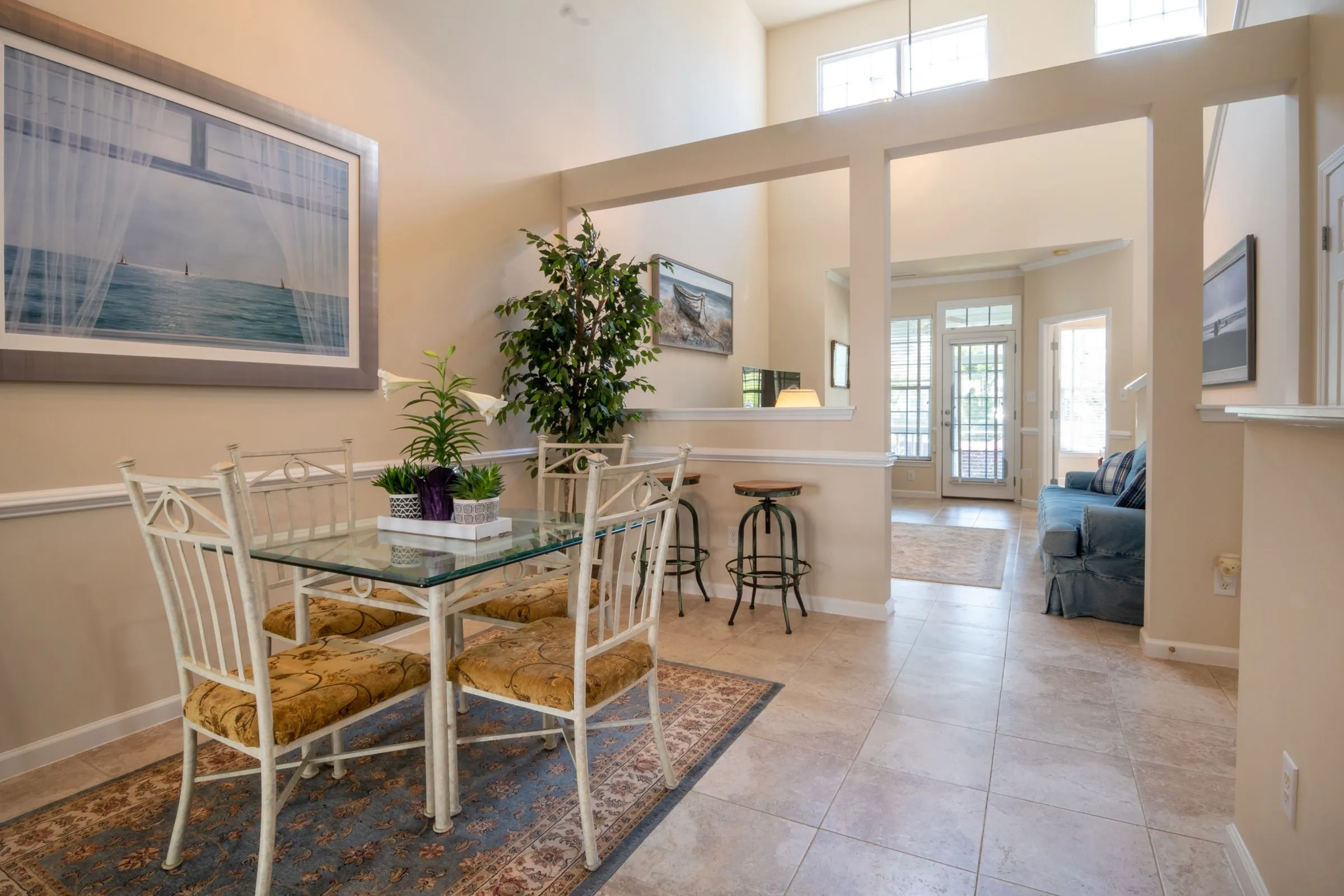 Dining area at Casa Terra opening onto the living room, lit by daylight from a tall window.