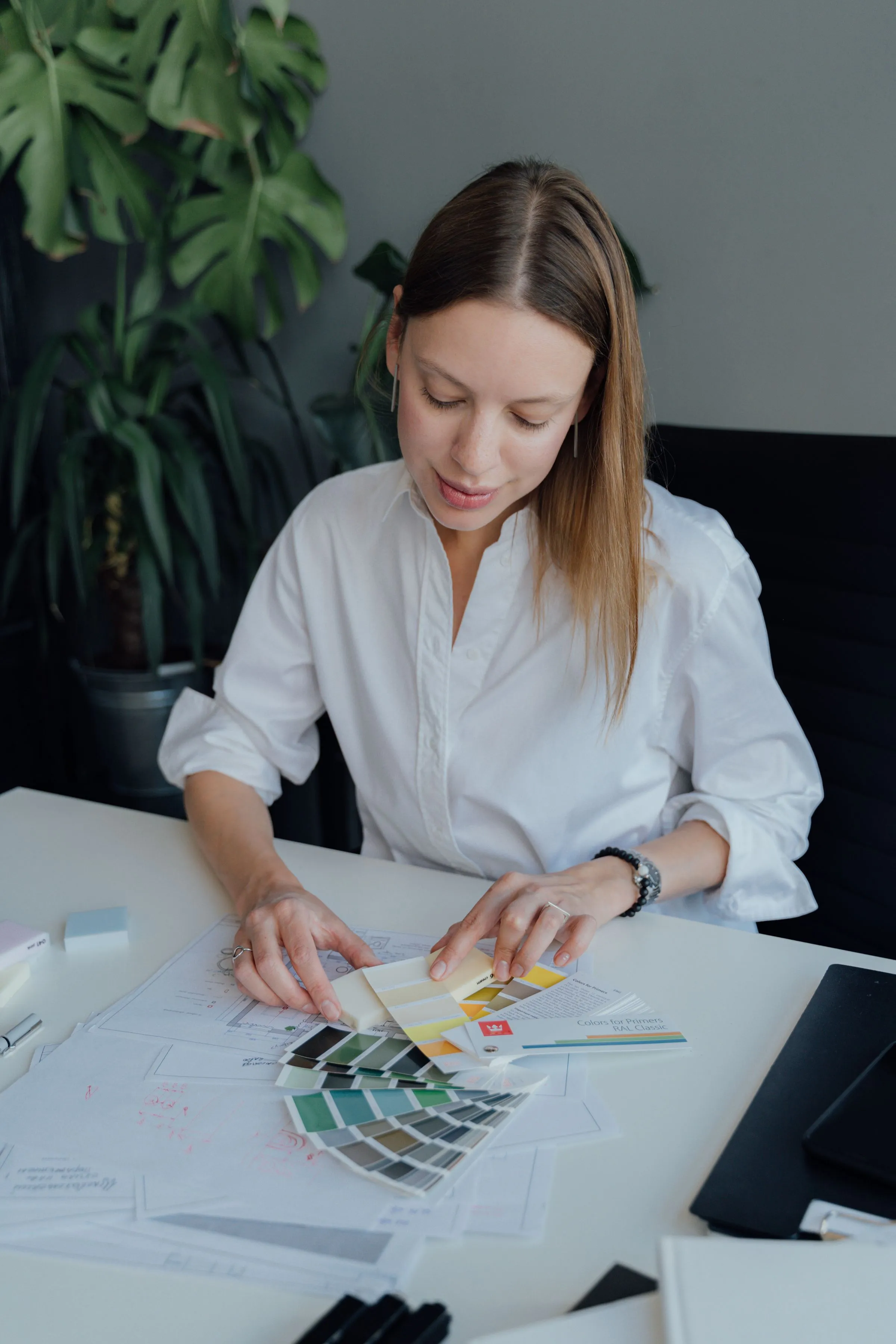 An interior designer laying out colour swatches across a work surface.