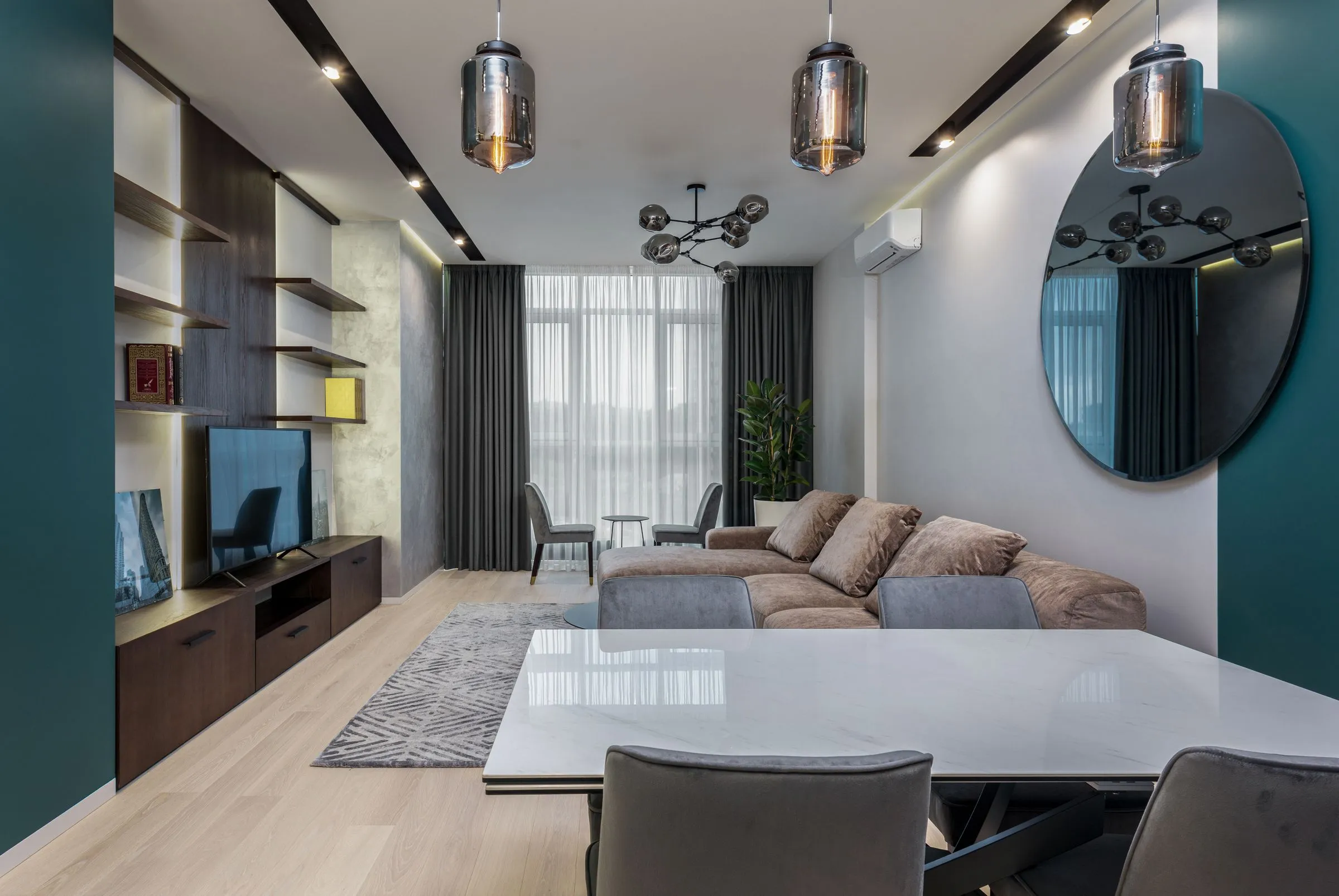 A dining table and chairs beside a sofa in a room mid-way through being furnished.