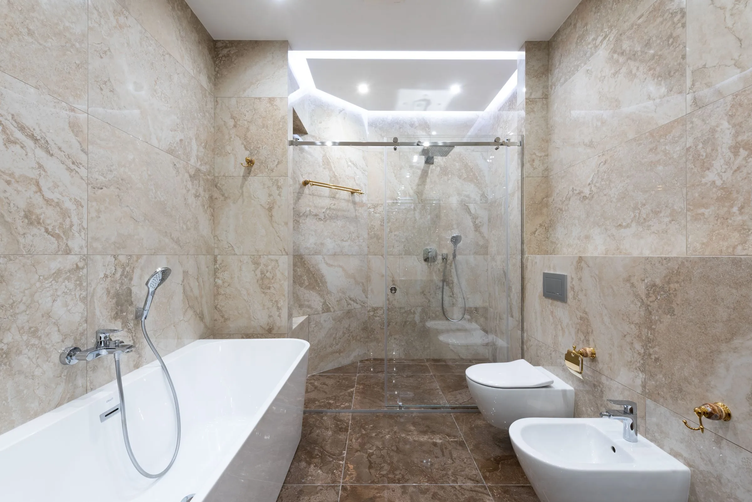 Guest bathroom at Hotel Marana with stone-clad walls and a walk-in shower.