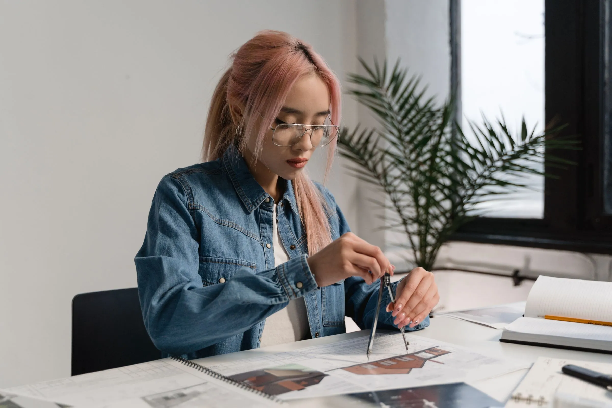 A designer working at a drawing board in a bright studio.