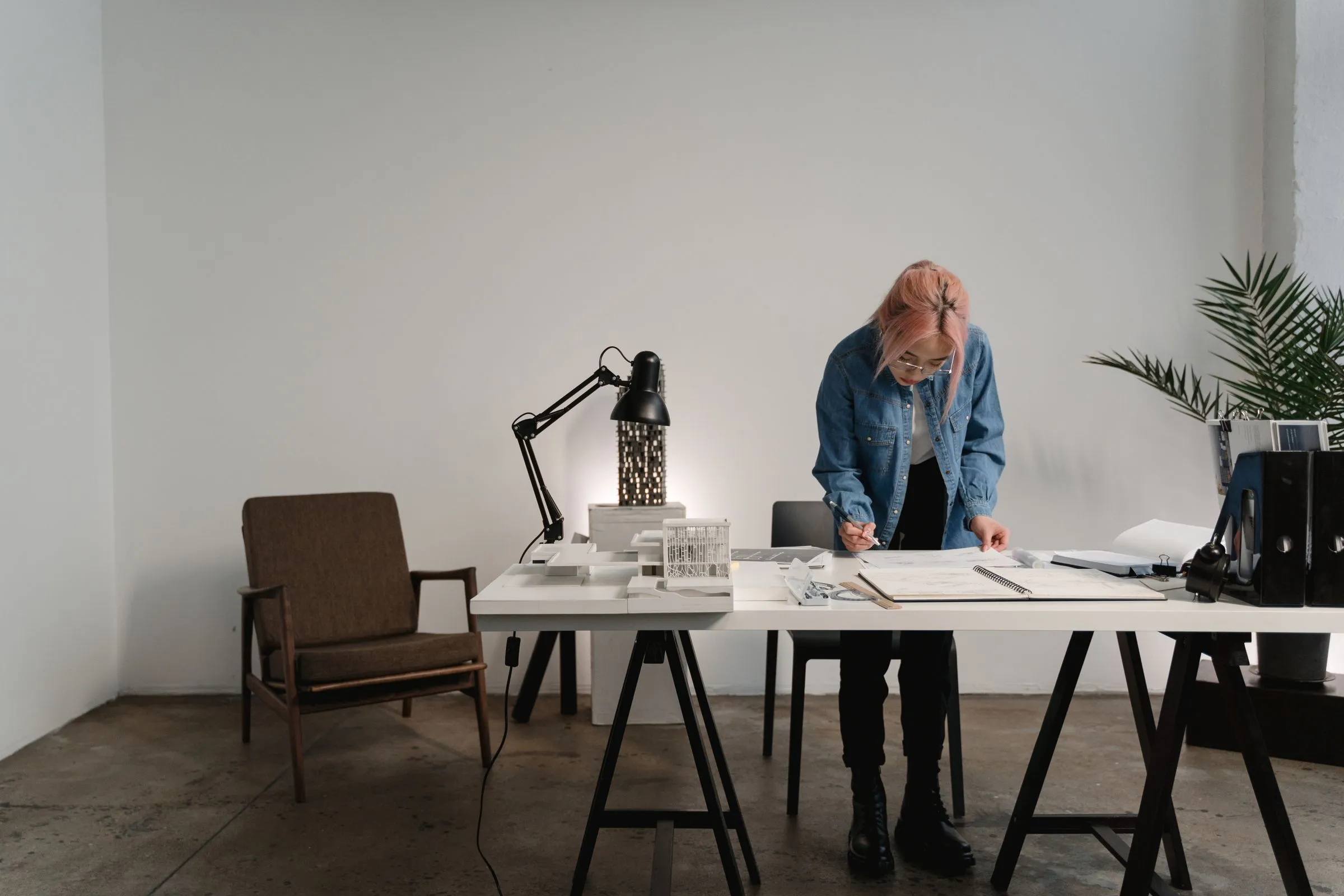 A project architect reviewing drawings at a desk in a modern office.