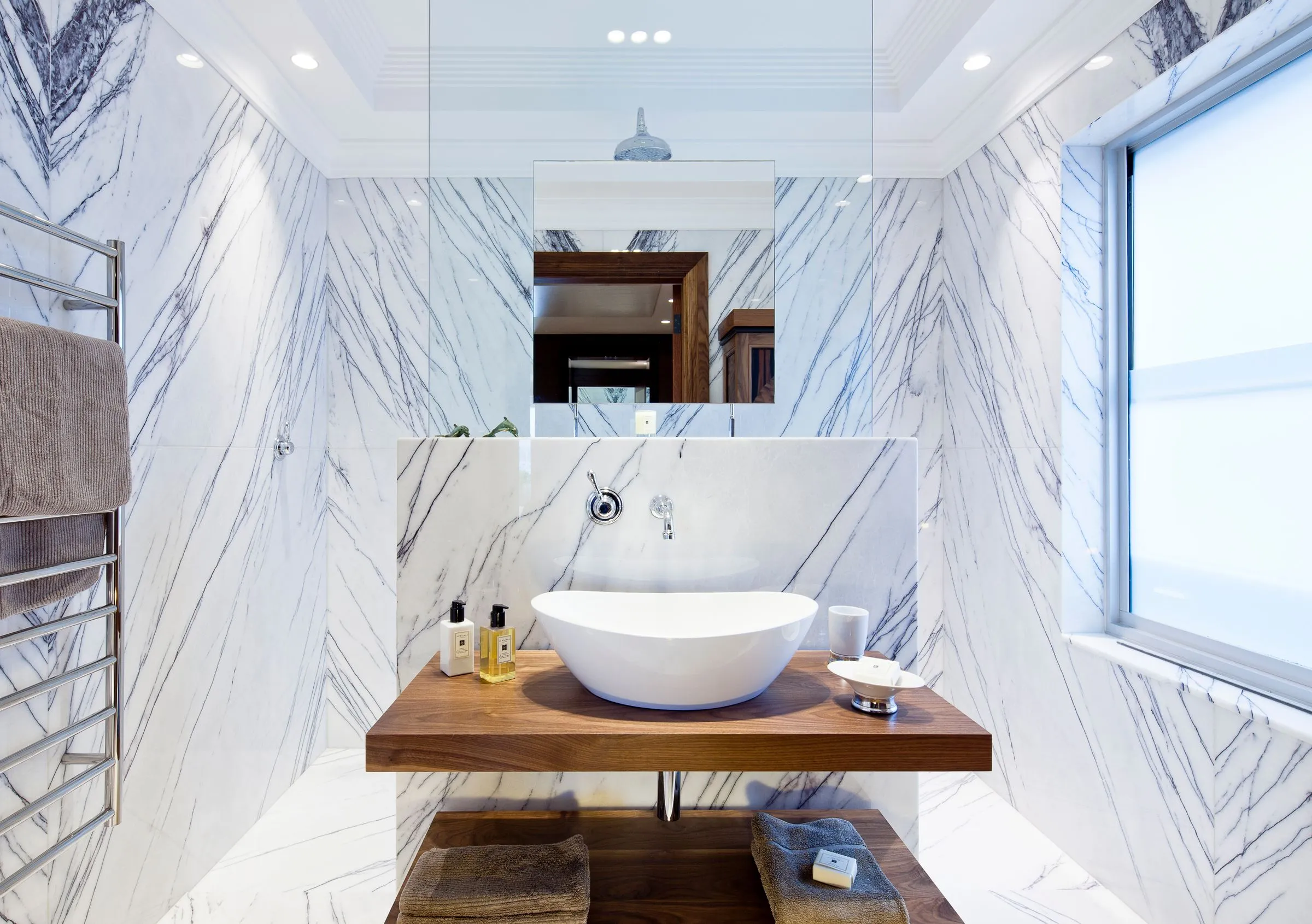 Bathroom at The Reading Room with marble-clad walls and a modern basin.