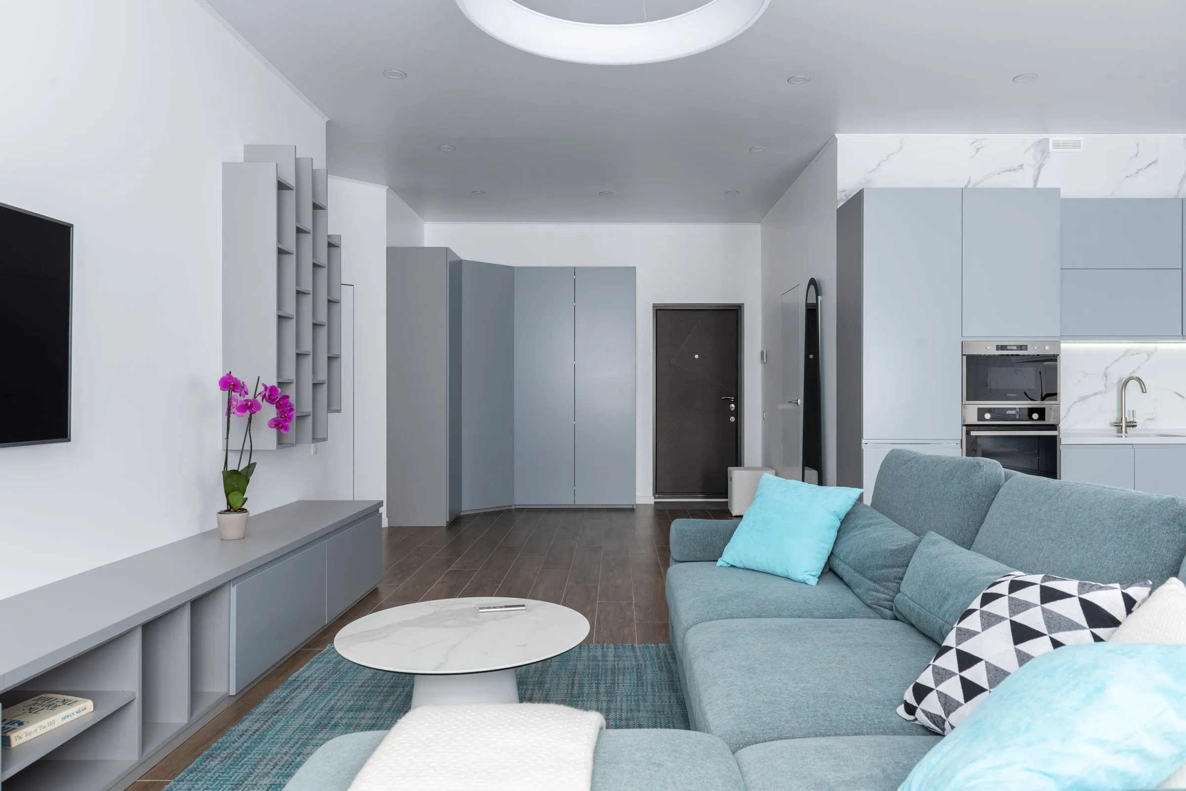 Living area at Kestrel House with a round side table and a wall-mounted shelf.