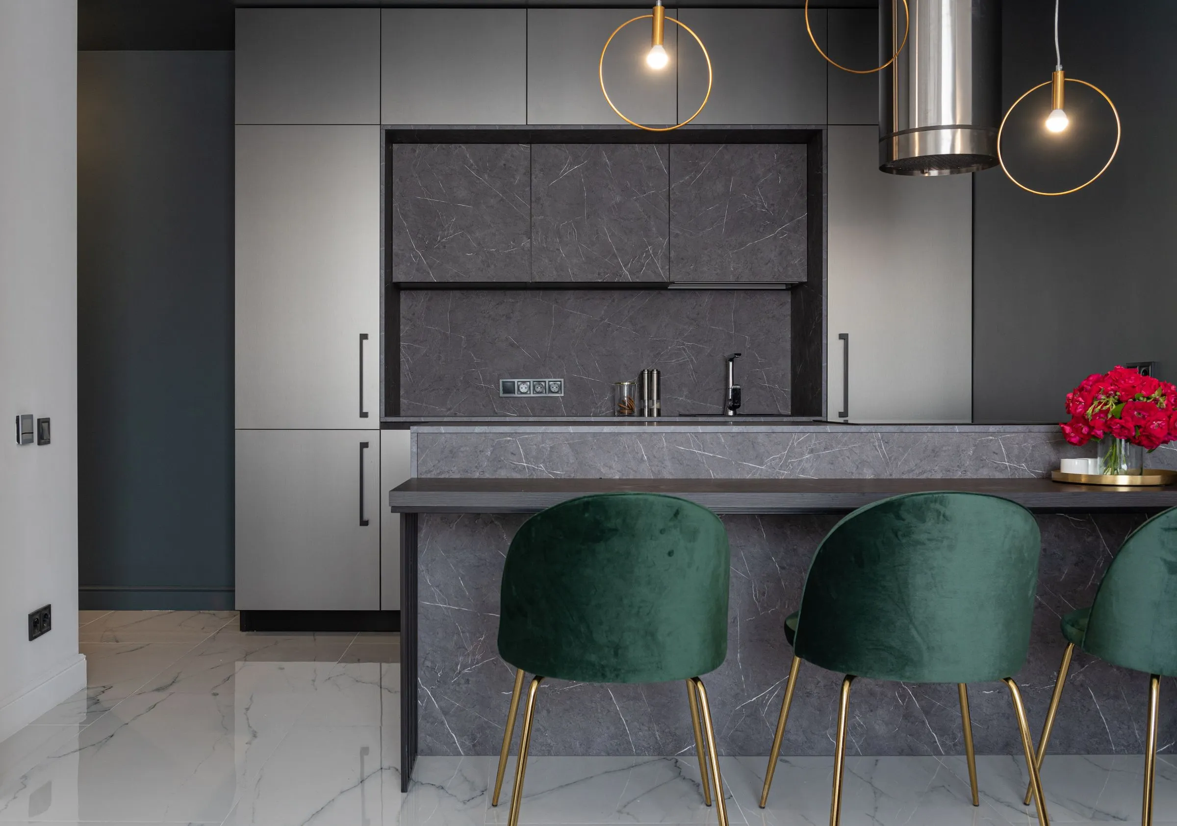 Casa Terra kitchen with a pale island, low armchairs and a vase of cut flowers.