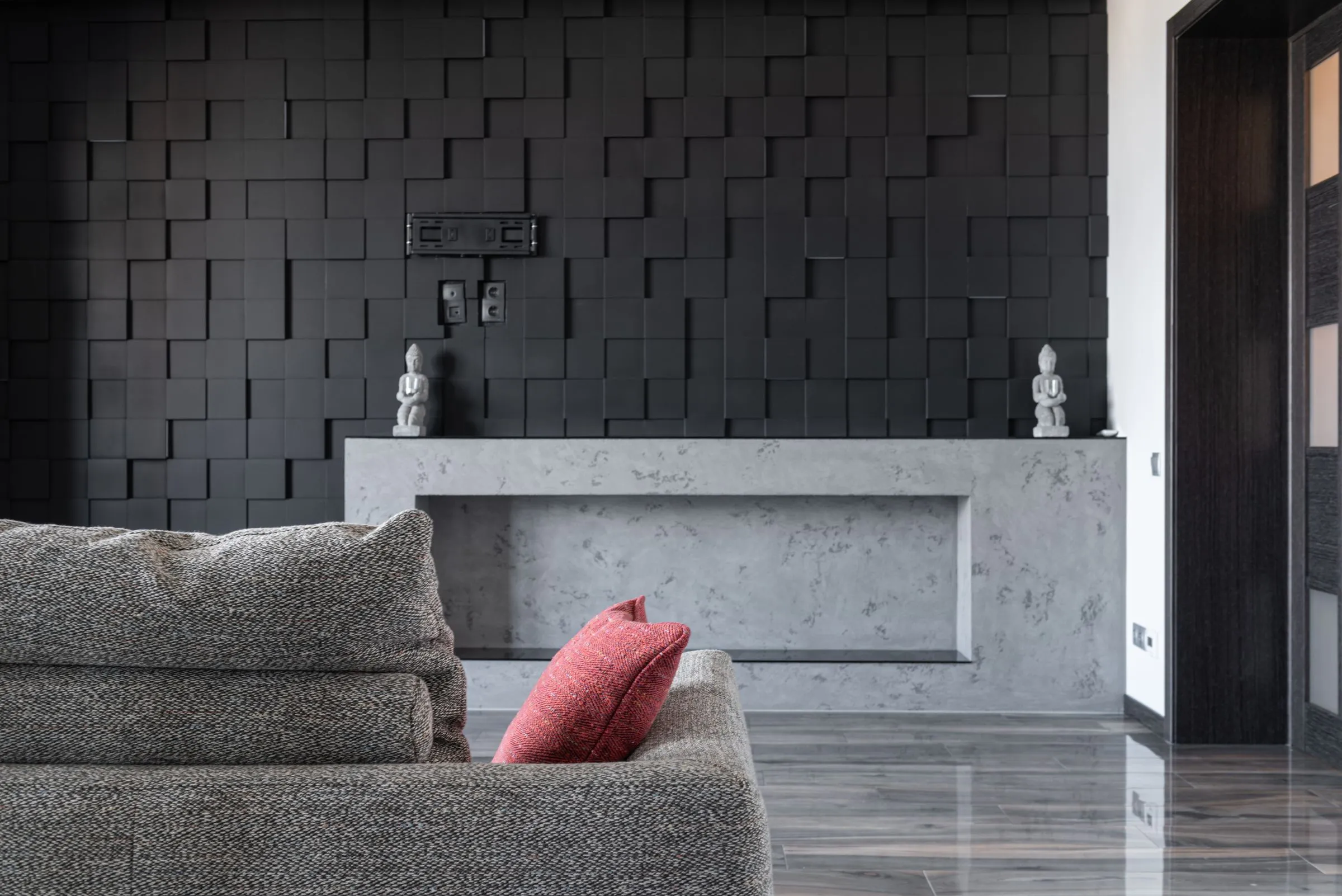 Living room at The Reading Room with a grey sofa against a textured dark wall.