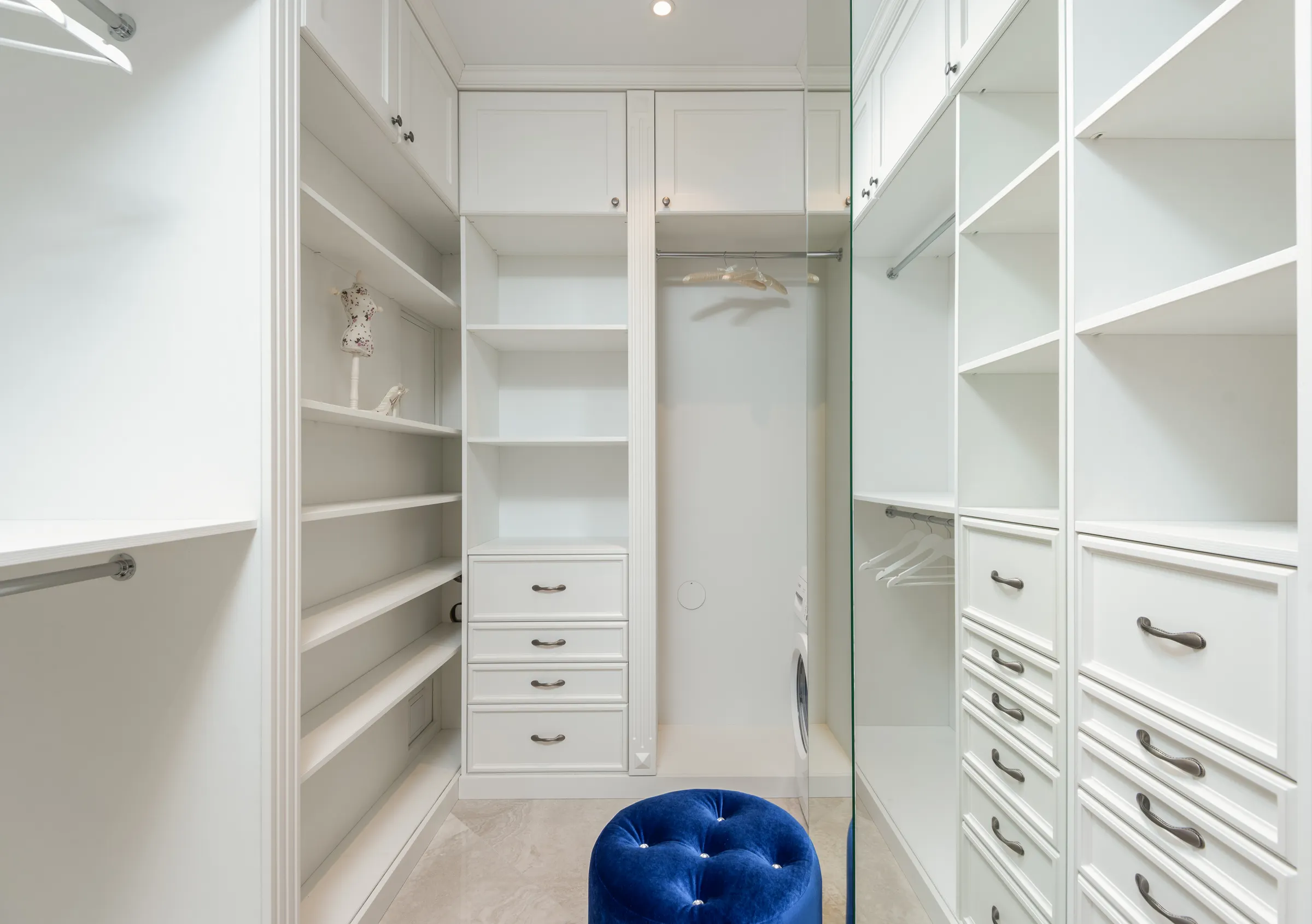 Empty fitted shelving and hanging rails in a room part-way through being refitted.