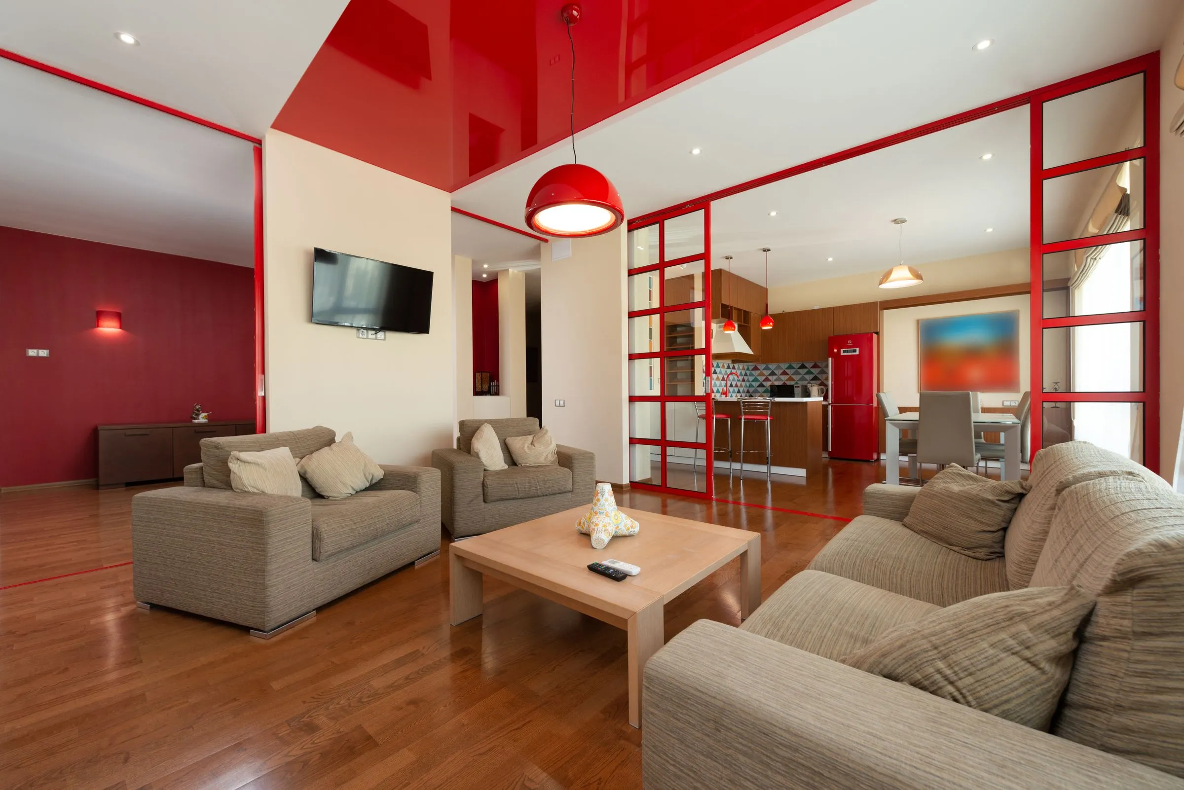 Serein living room with a pale sofa, two armchairs and daylight across a timber floor.