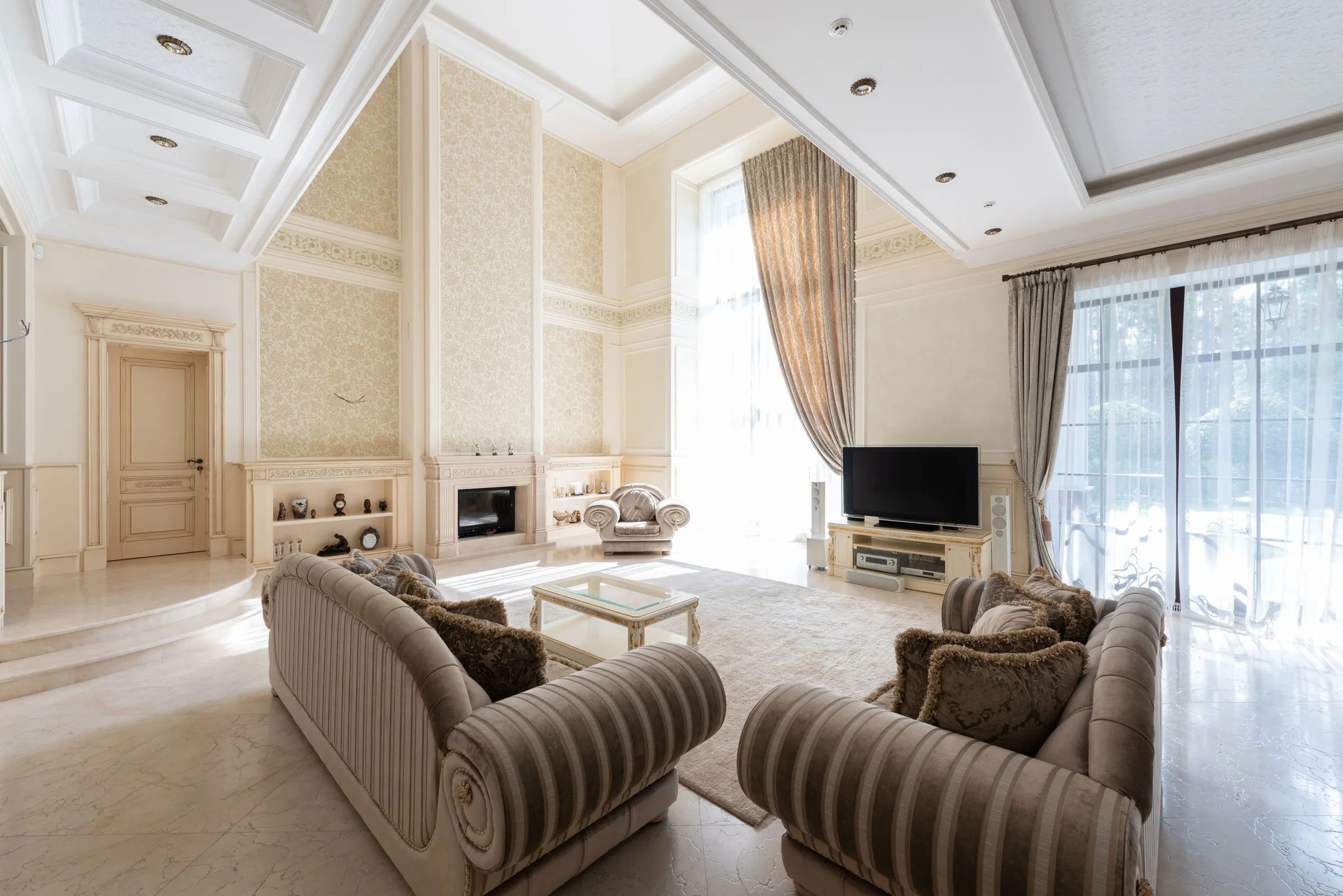 A meeting-height room with a long sofa, a low table and daylight from tall windows.