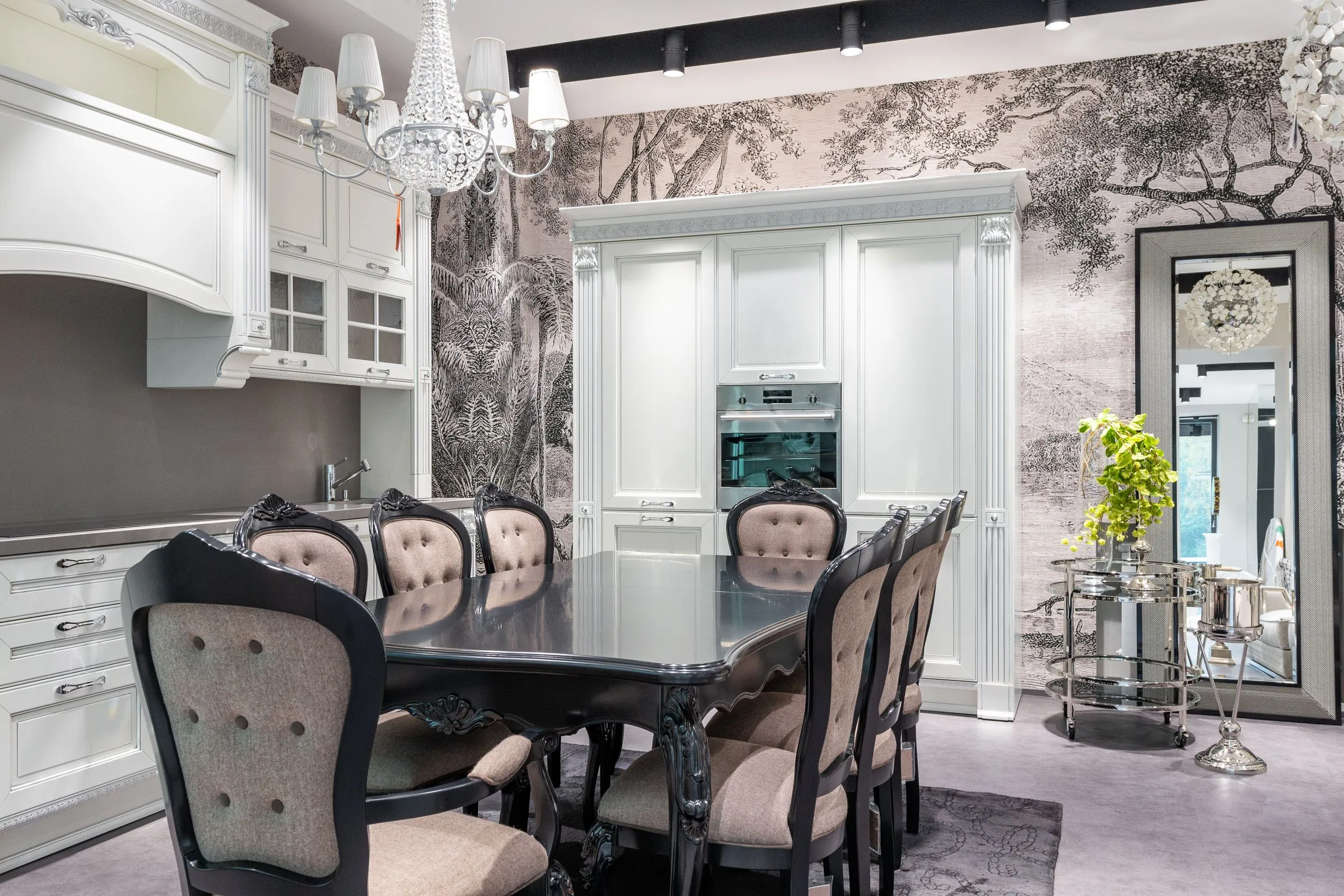 A compact kitchen with white cabinets, an oven and a plant on the sill.