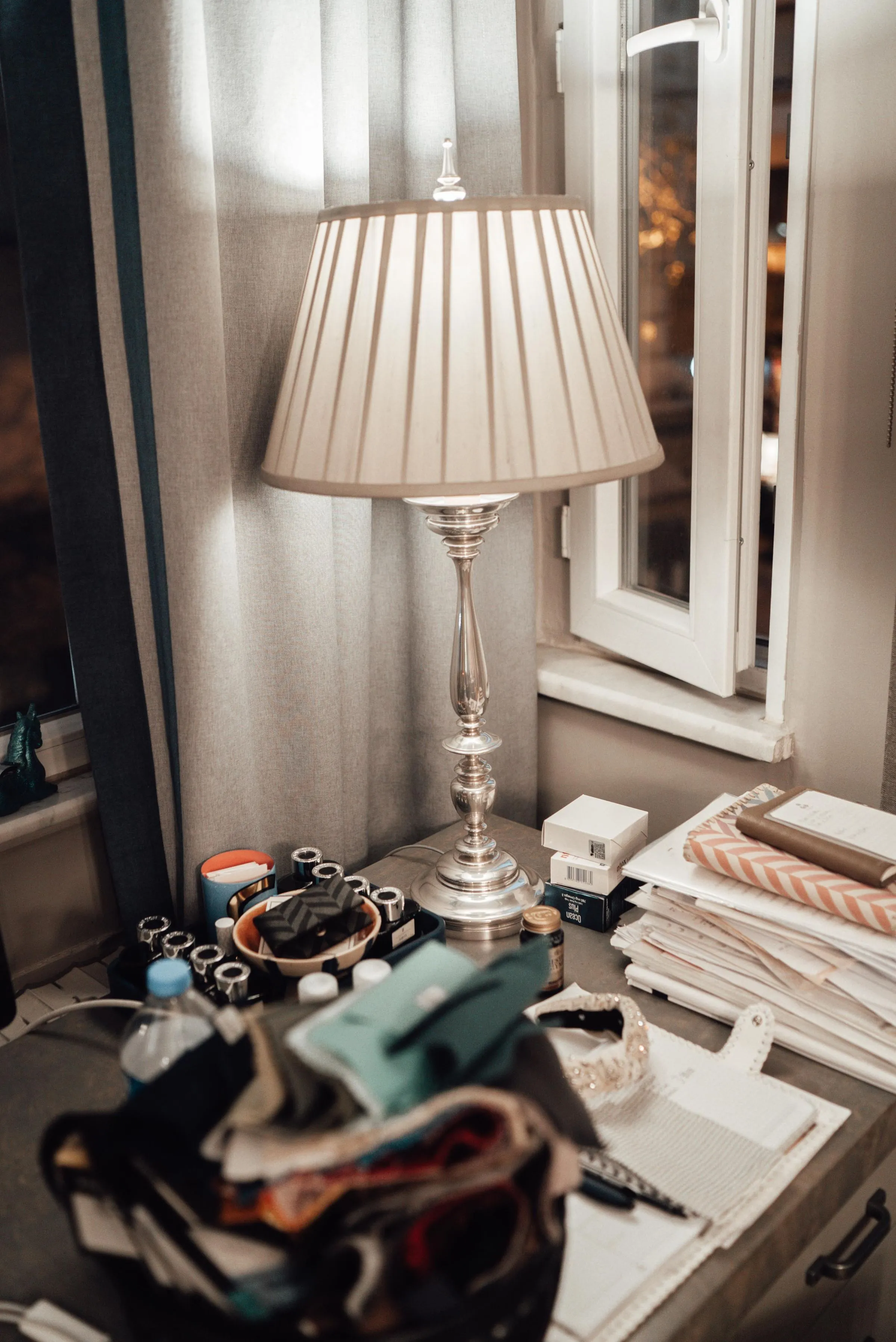Desk corner at The Reading Room with a vintage table lamp and a view to the window.