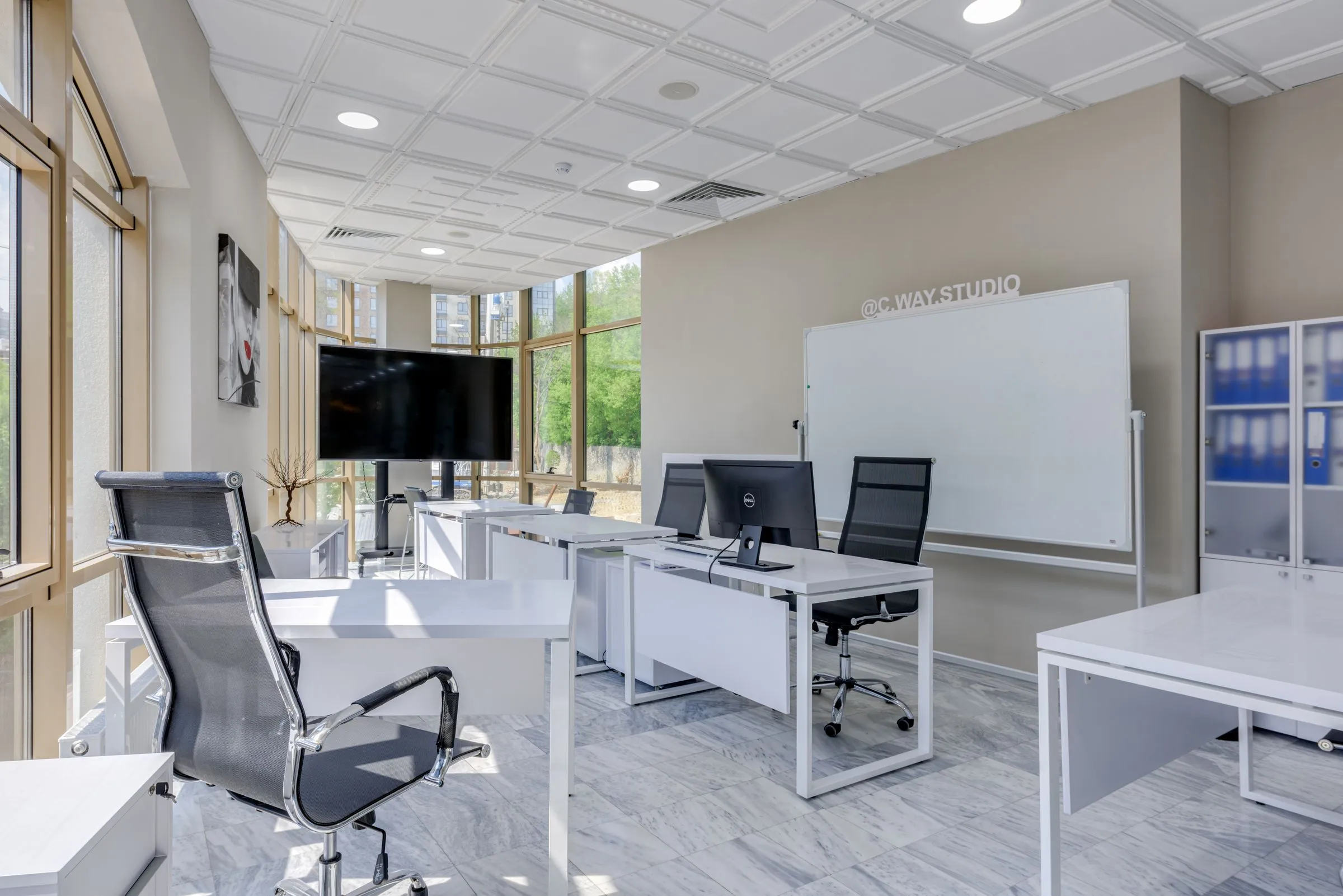 Northlight Studio open workspace with pale desks and even, diffused daylight from tall windows.