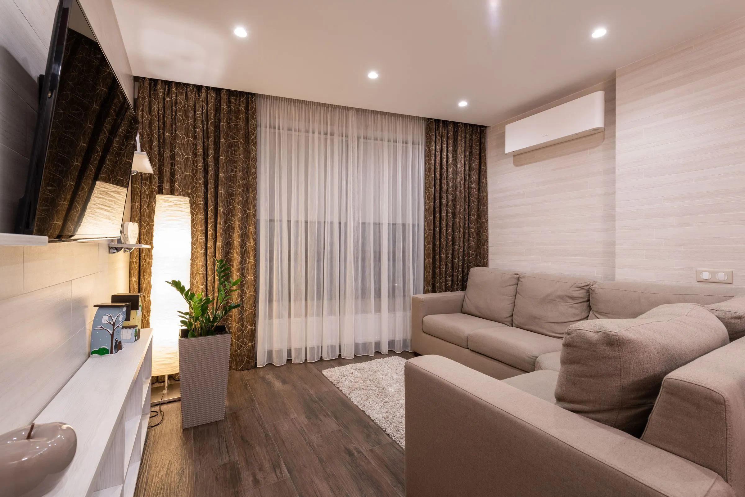 Living room at Kestrel House with a compact sofa, timber flooring and soft daylight.