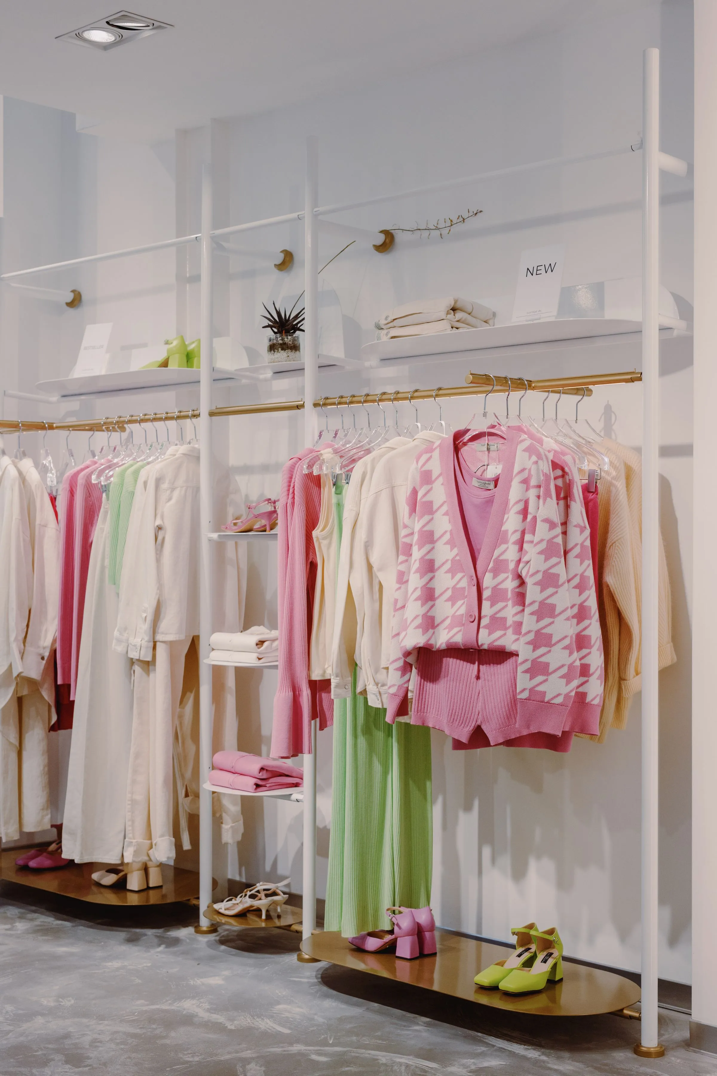 Display of garments and accessories at Vault & Vine beside the fitting-room block.