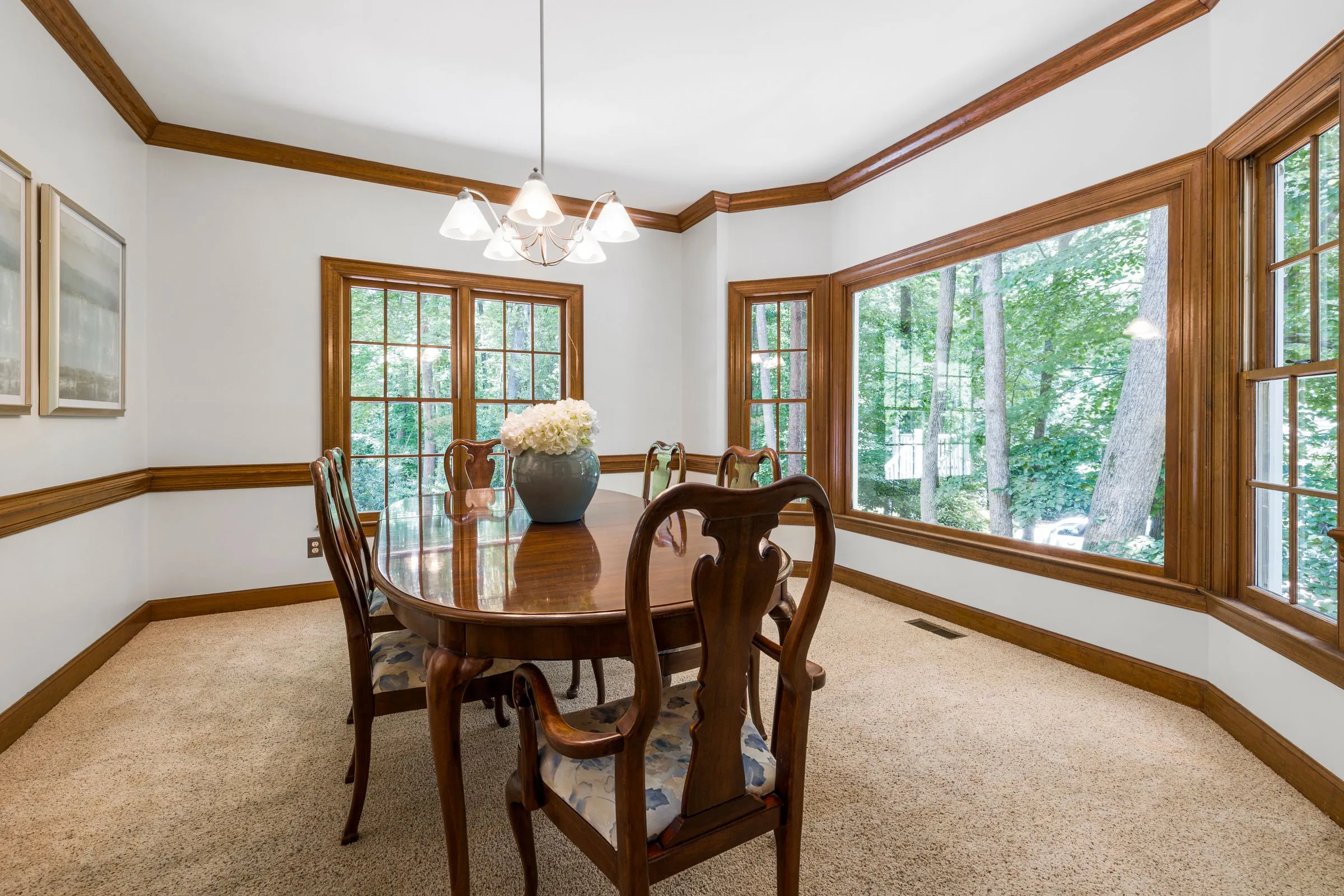 Dining room at The Oak House with a long timber table and tall windows onto the garden.