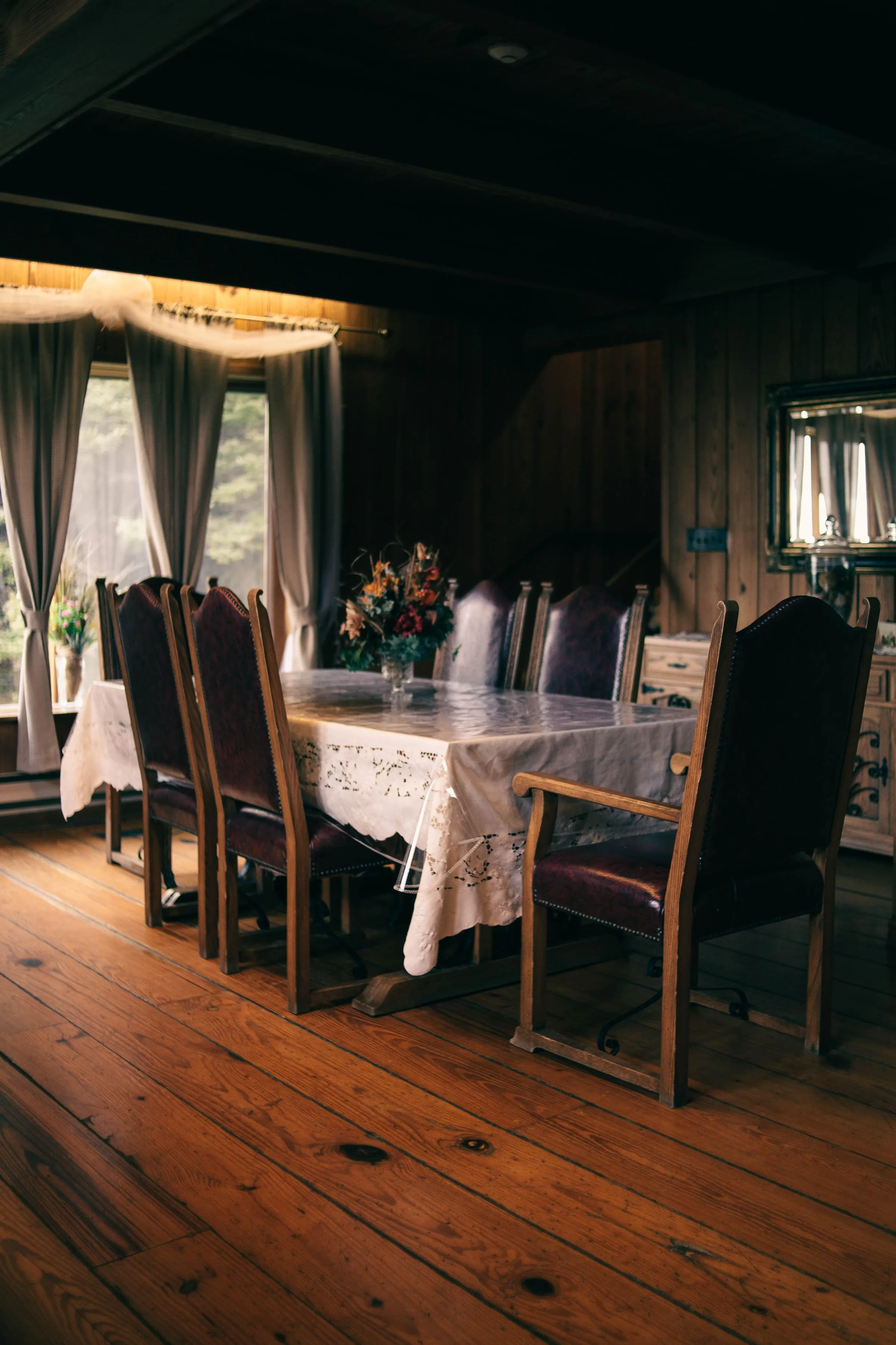 A dining room with timber furniture, warm walls and soft lighting.