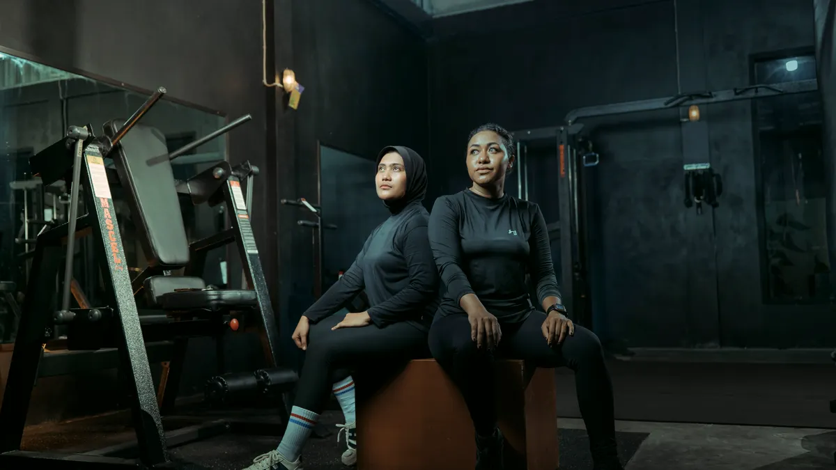Two members sitting together on a plyo box after a session