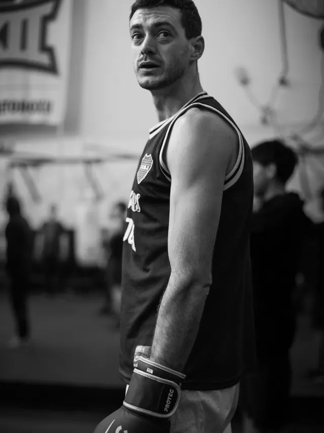 Portrait of a boxer in wraps and gloves inside a training gym