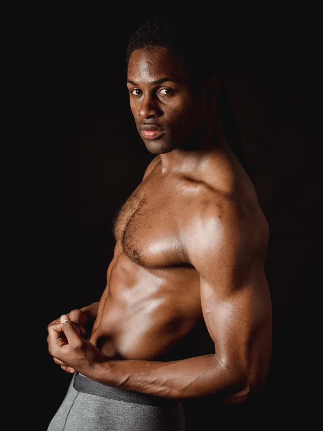 Studio portrait of a coach lit from one side against black
