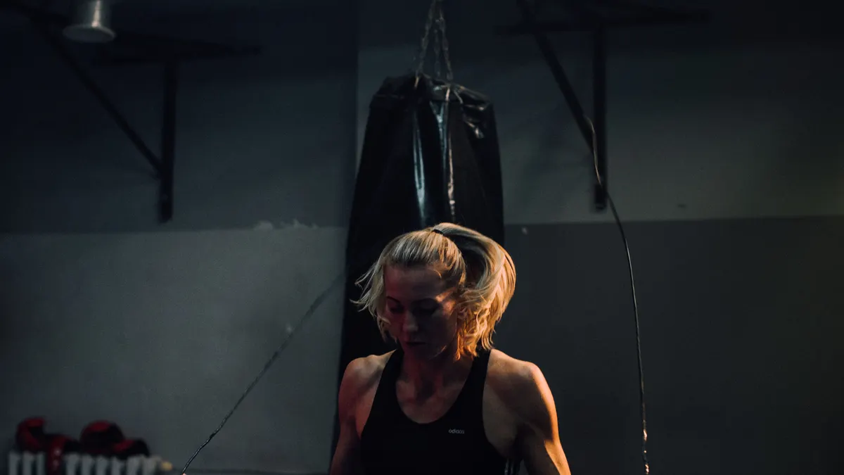 Athlete skipping rope beneath a single strip light