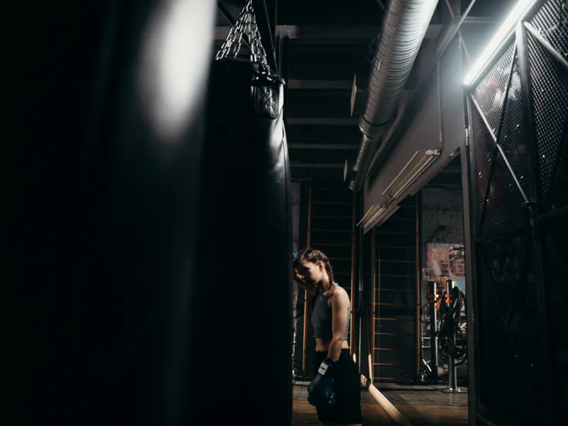 Heavy bags hanging in a darkened boxing room
