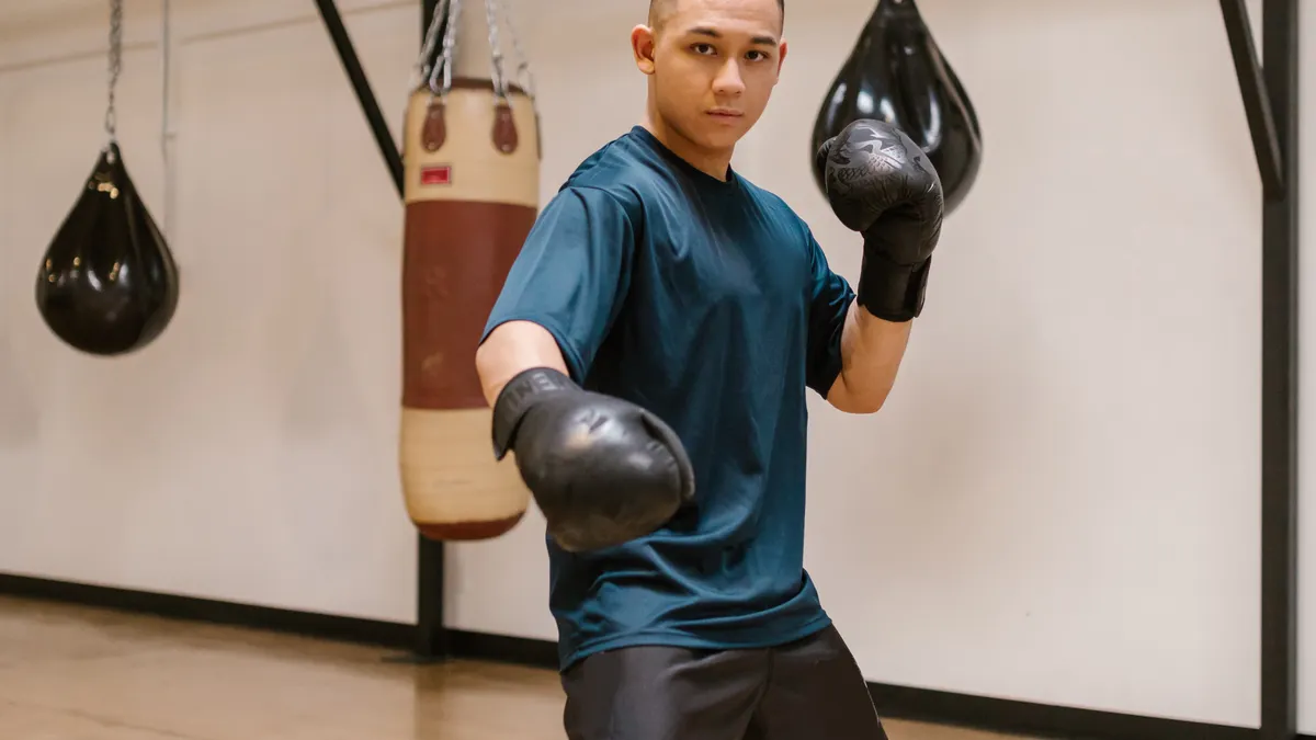 Boxer working footwork drills in a bright timber studio