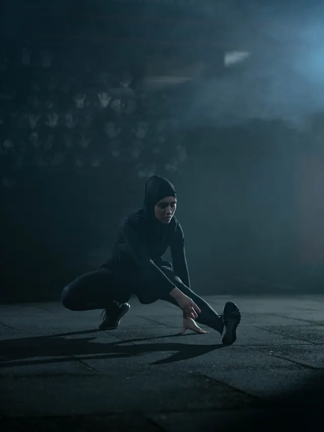 Athlete holding a deep side lunge in a smoke-lit studio