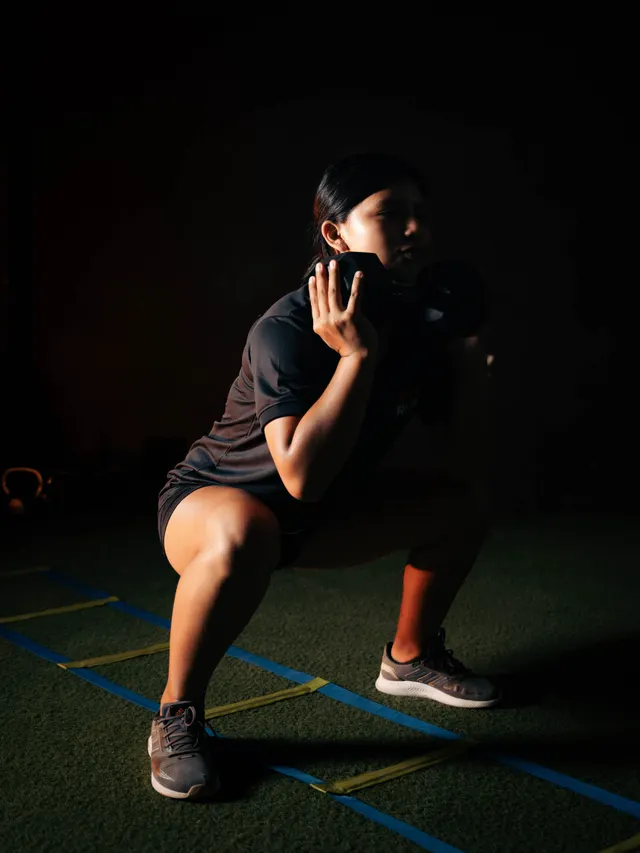 Athlete holding a loaded squat on an indoor track
