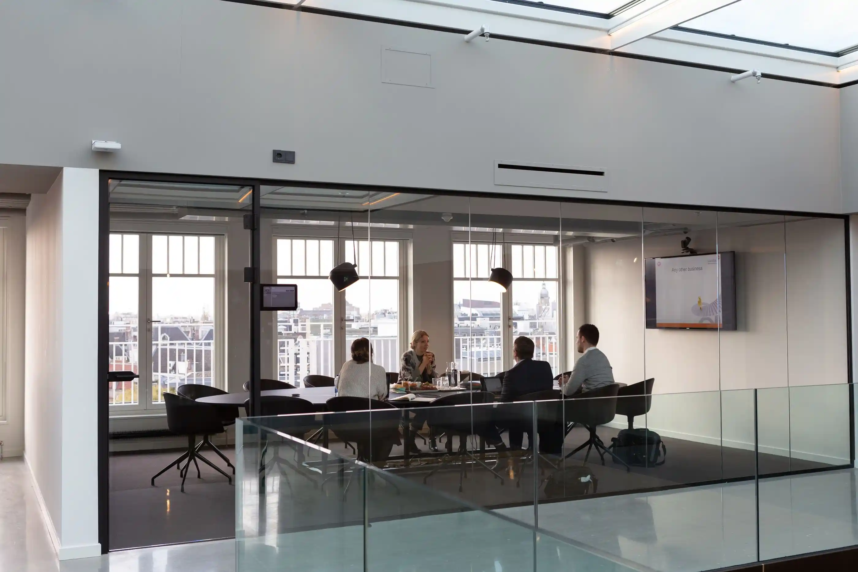A meeting underway in a glass-walled studio room