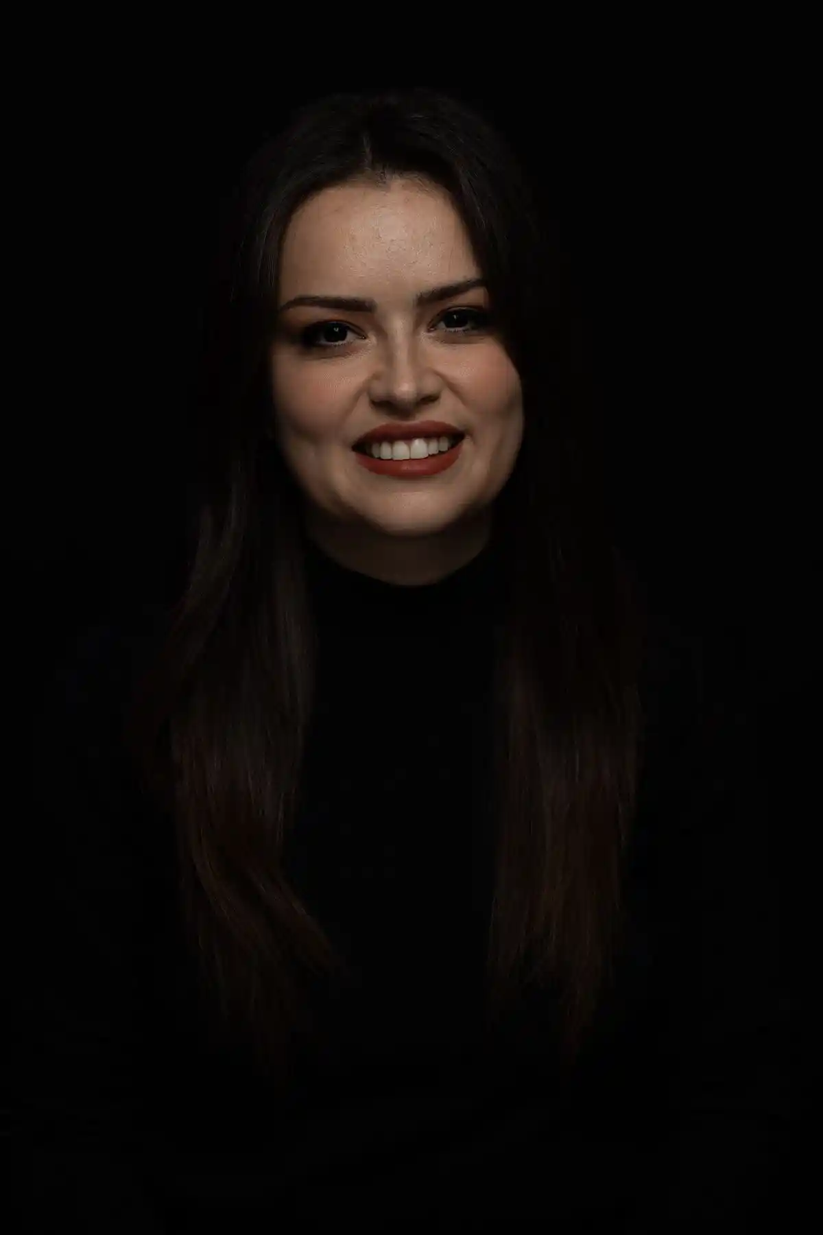 Portrait of a woman lit softly against a dark ground