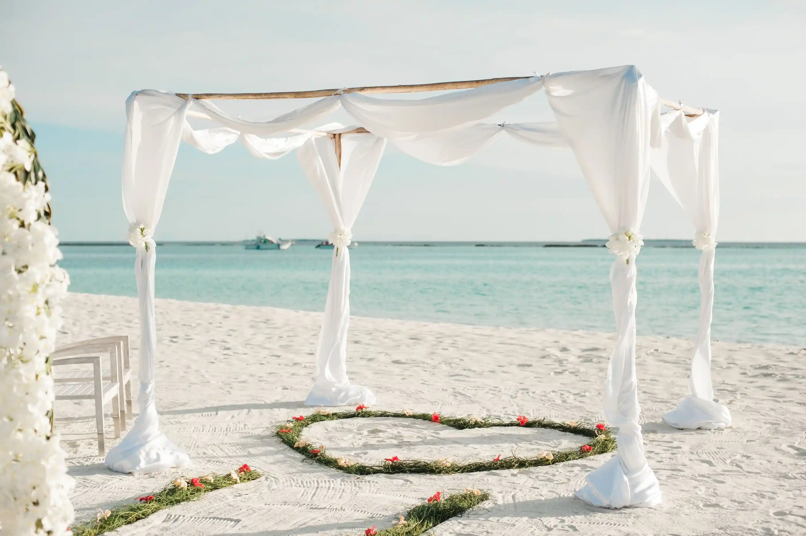 A flower-covered arch on the shoreline in bright sun
