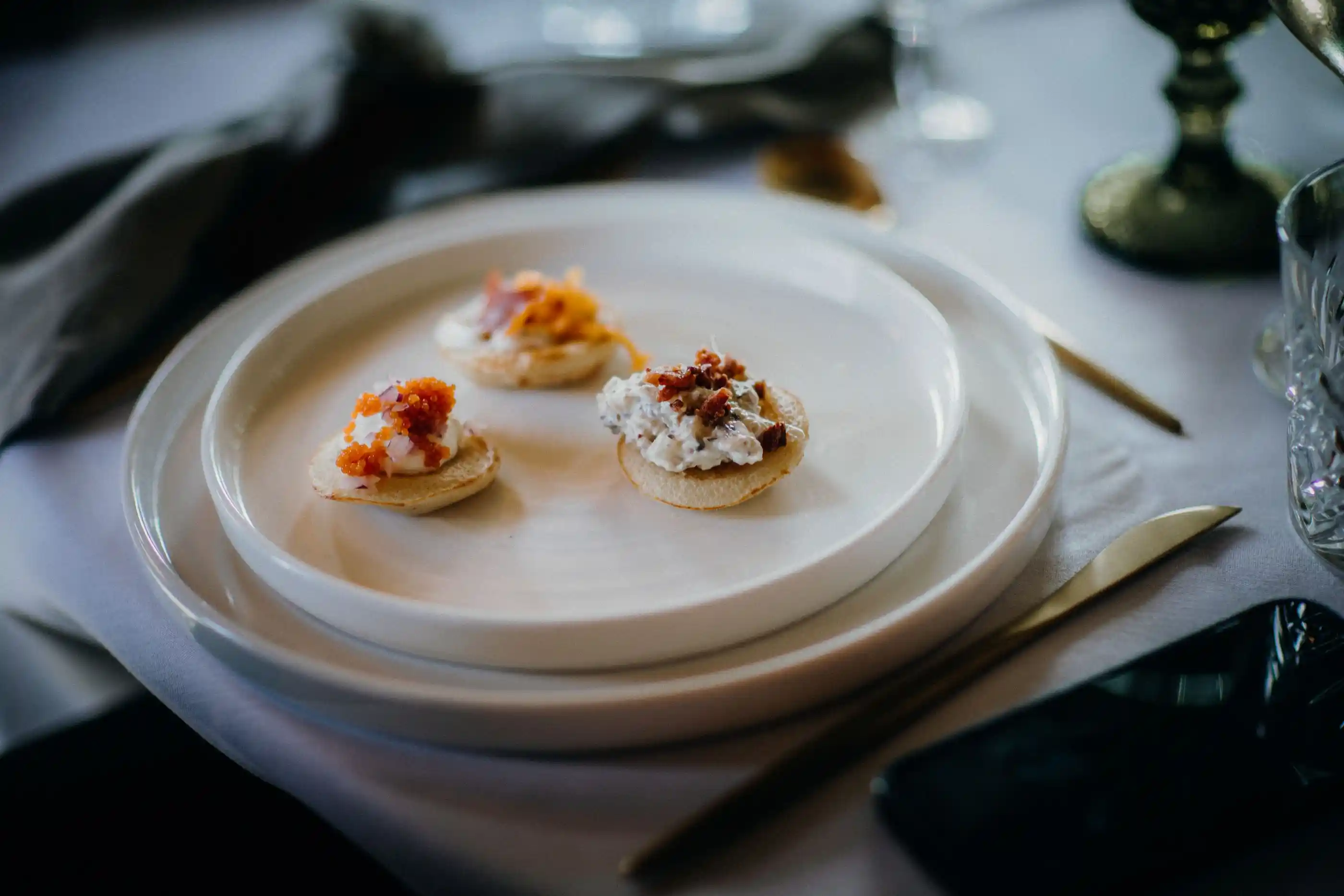 Canapés arranged on small white plates ready for service