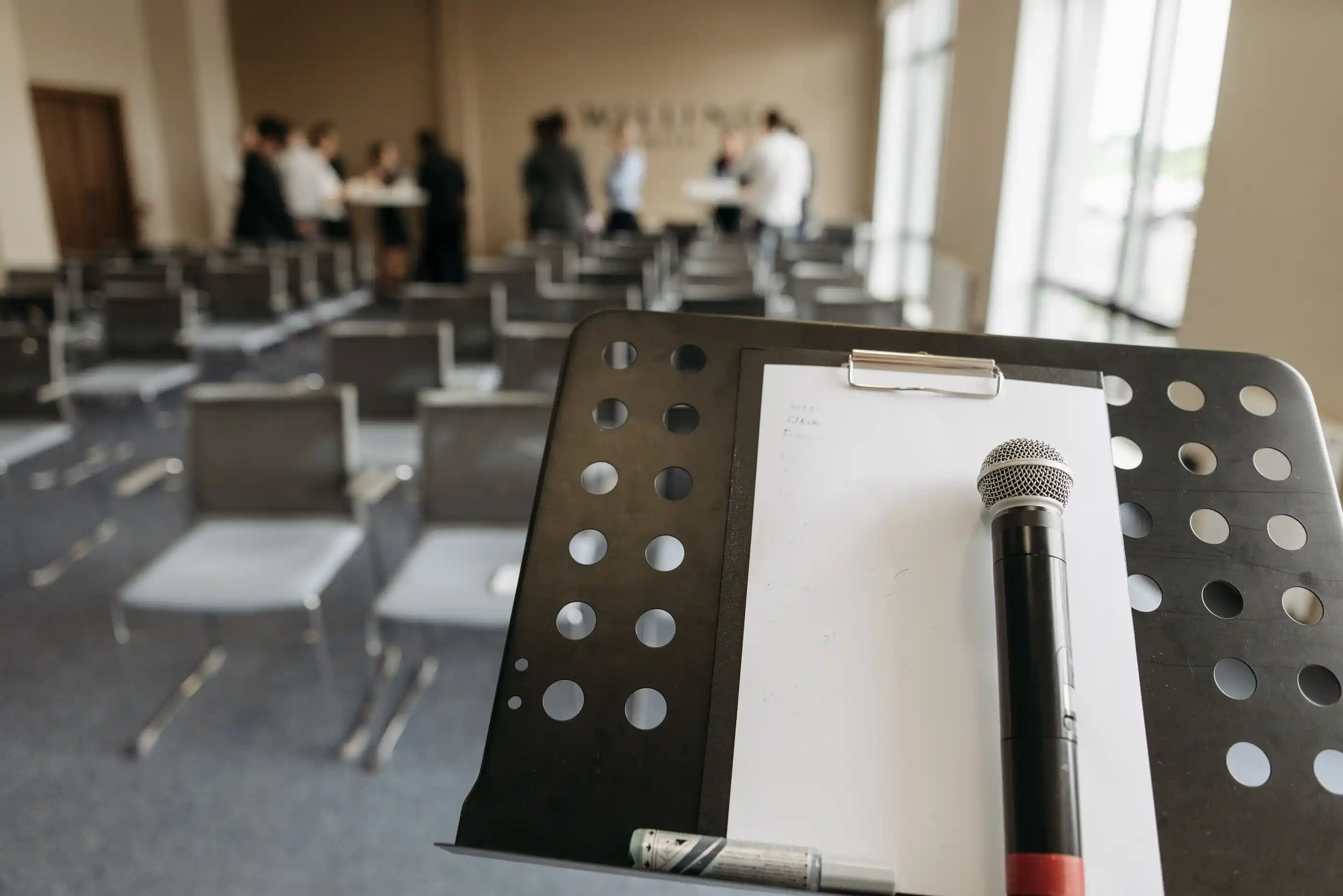 A microphone on a stand, the room out of focus behind it