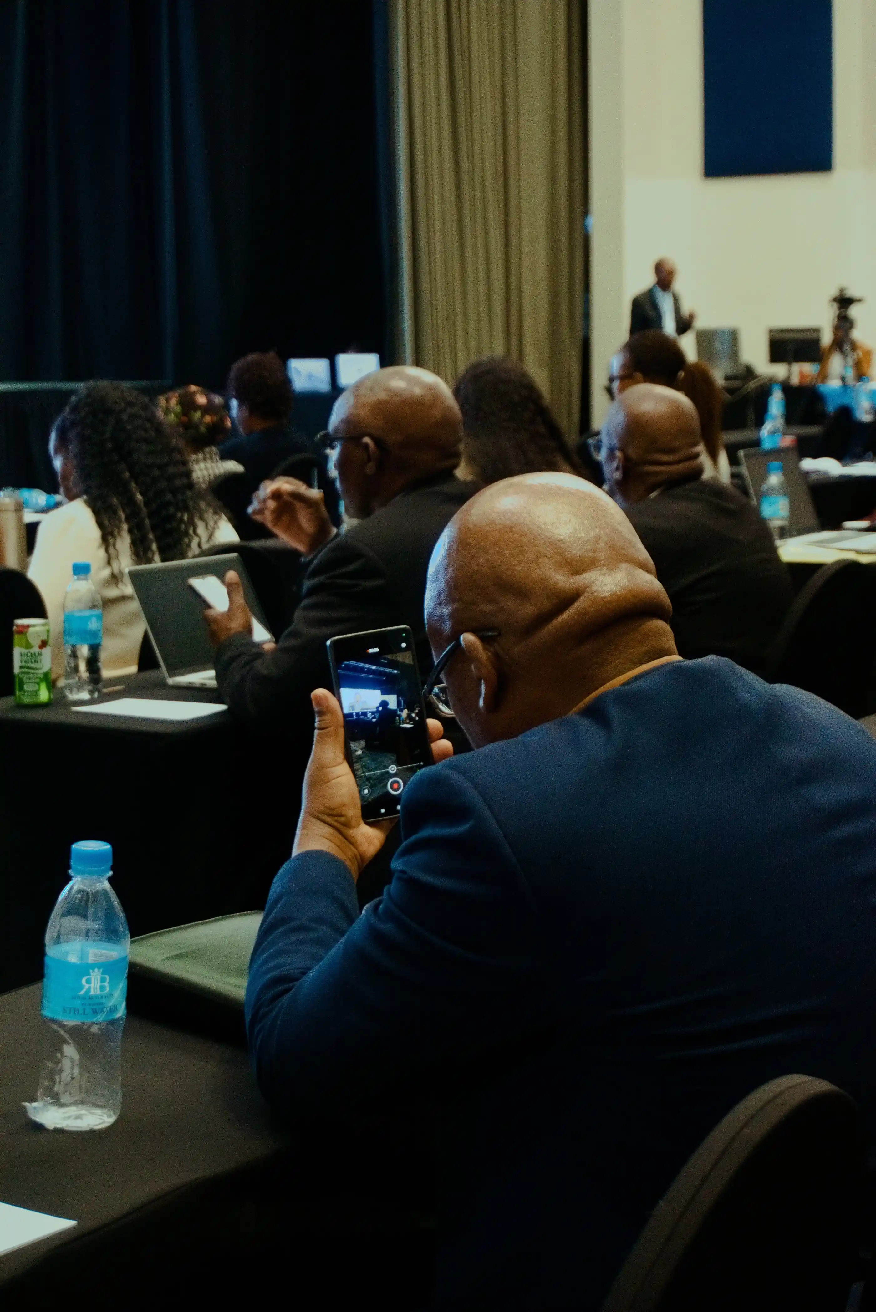 Attendees photographing a presentation on their phones