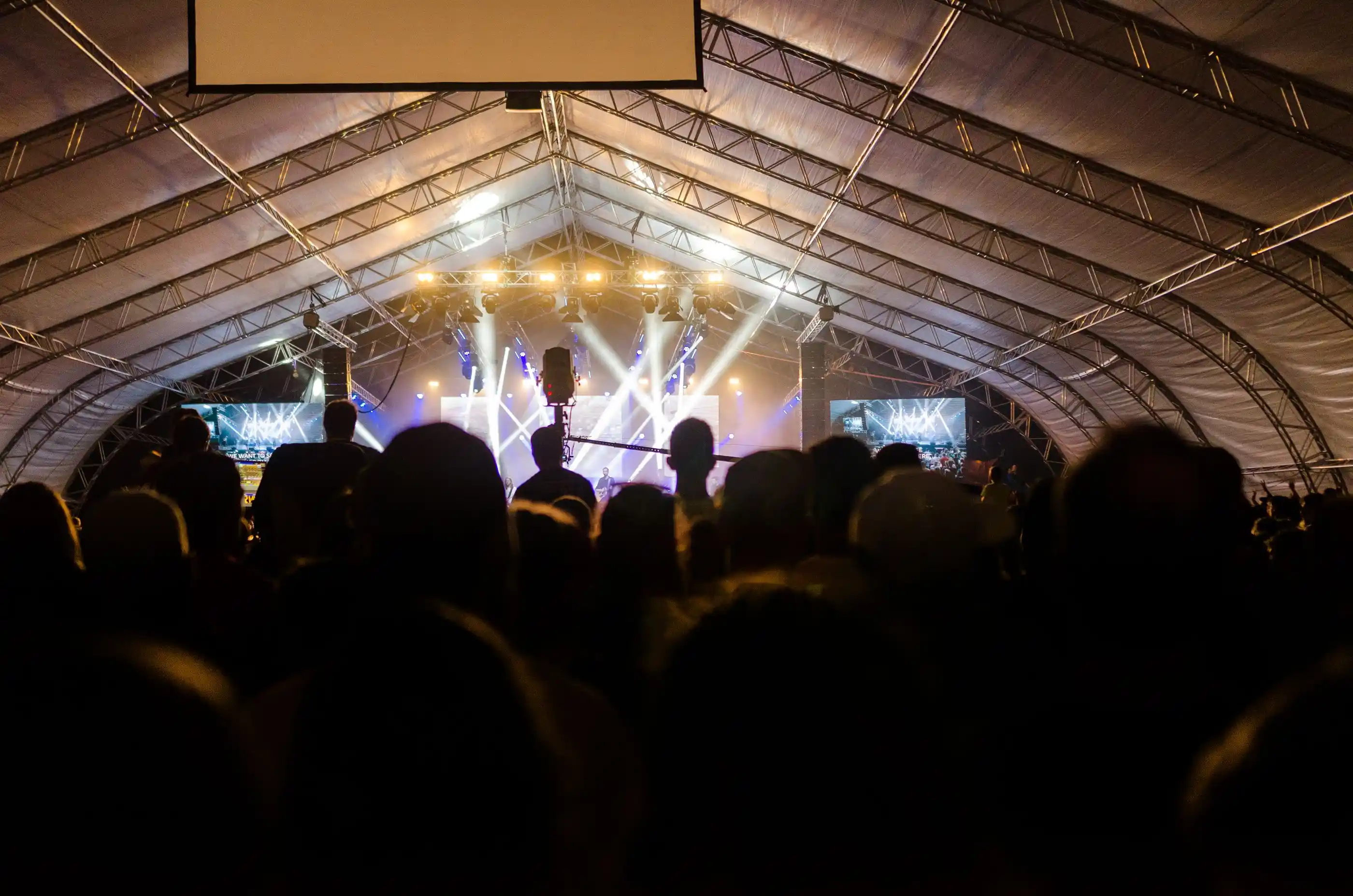 An indoor concert crowd lit from the stage