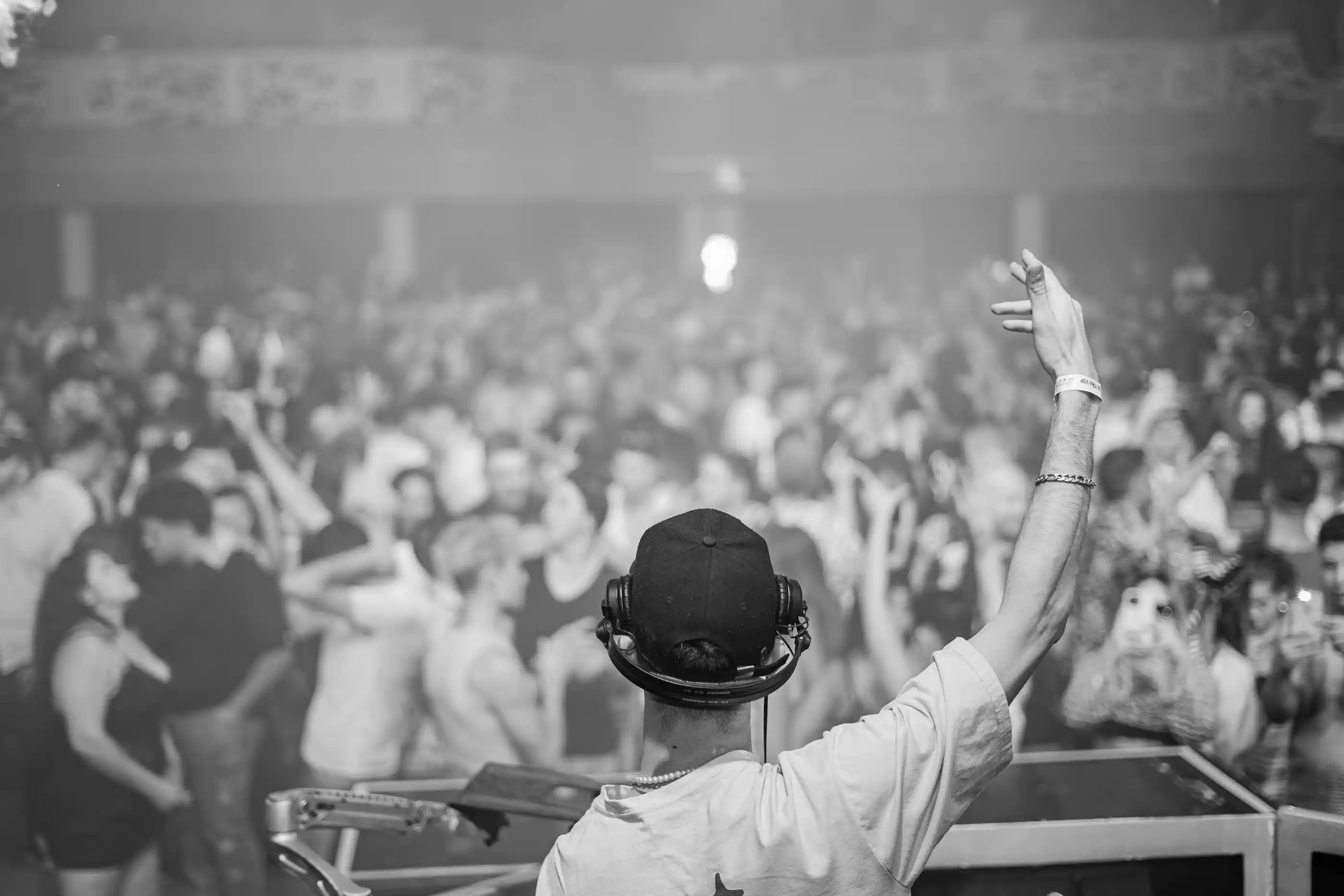 A DJ working the booth in front of a full floor