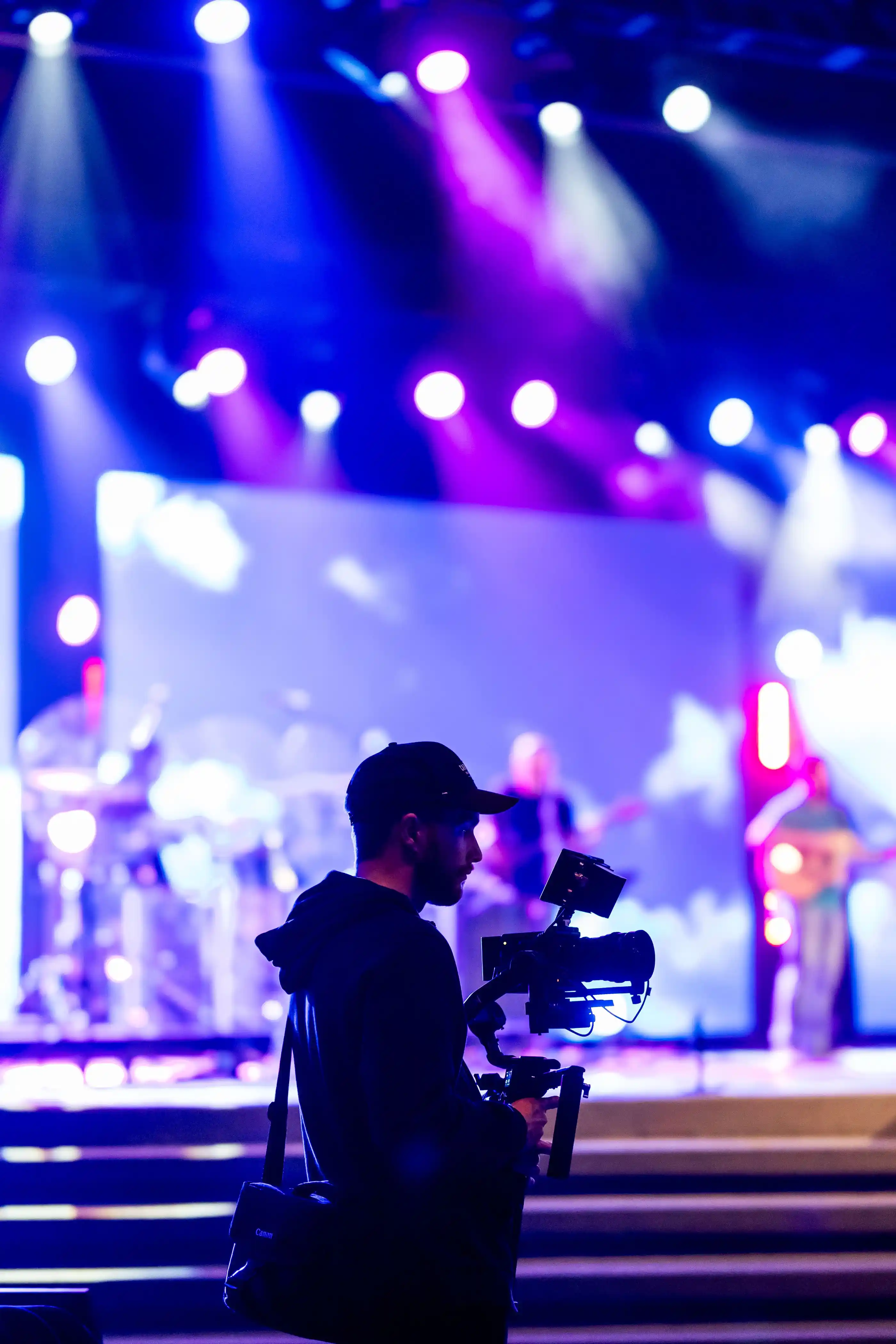 A videographer recording a concert from the front of house position